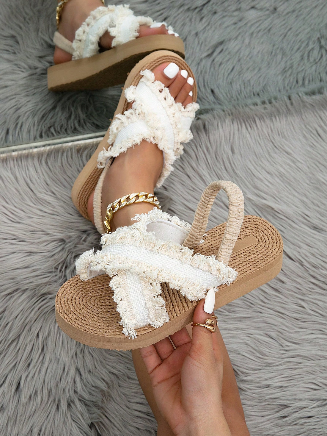 Women's open toe slip-on wedge sandals with criss cross straps and folk-custom styling, featuring raw hem, fringe, tassel, braid, and tape details.