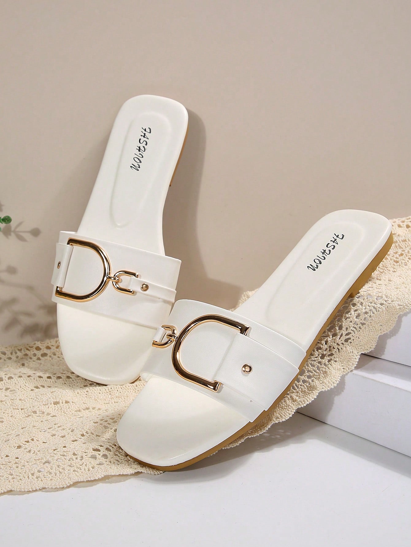 Pair of women’s wide fit flat slide sandals with an open toe, slip-on style, plain design, and gold buckle detail.