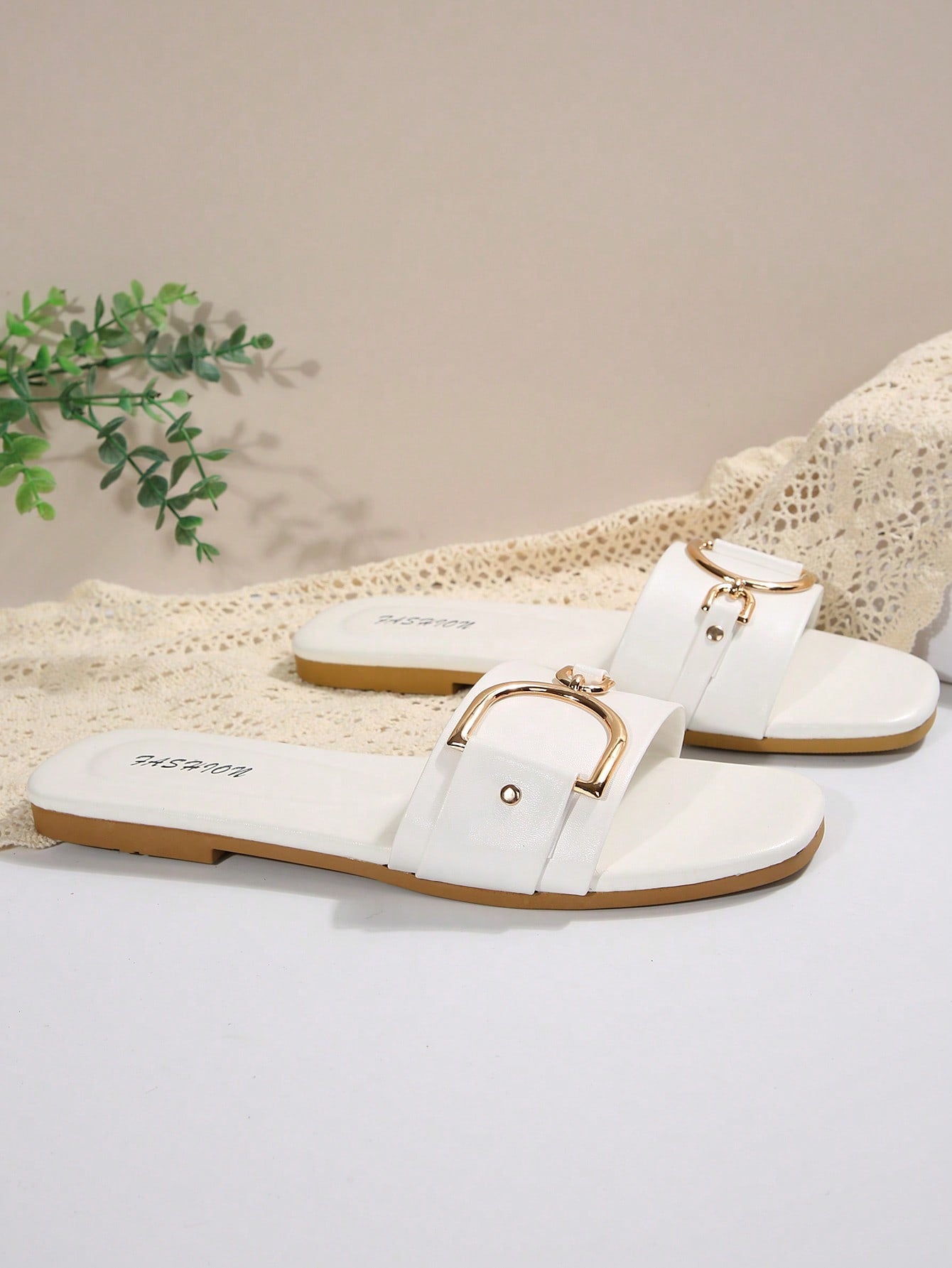 Pair of women’s wide fit flat slide sandals with an open toe, slip-on style, plain design, and gold buckle detail.
