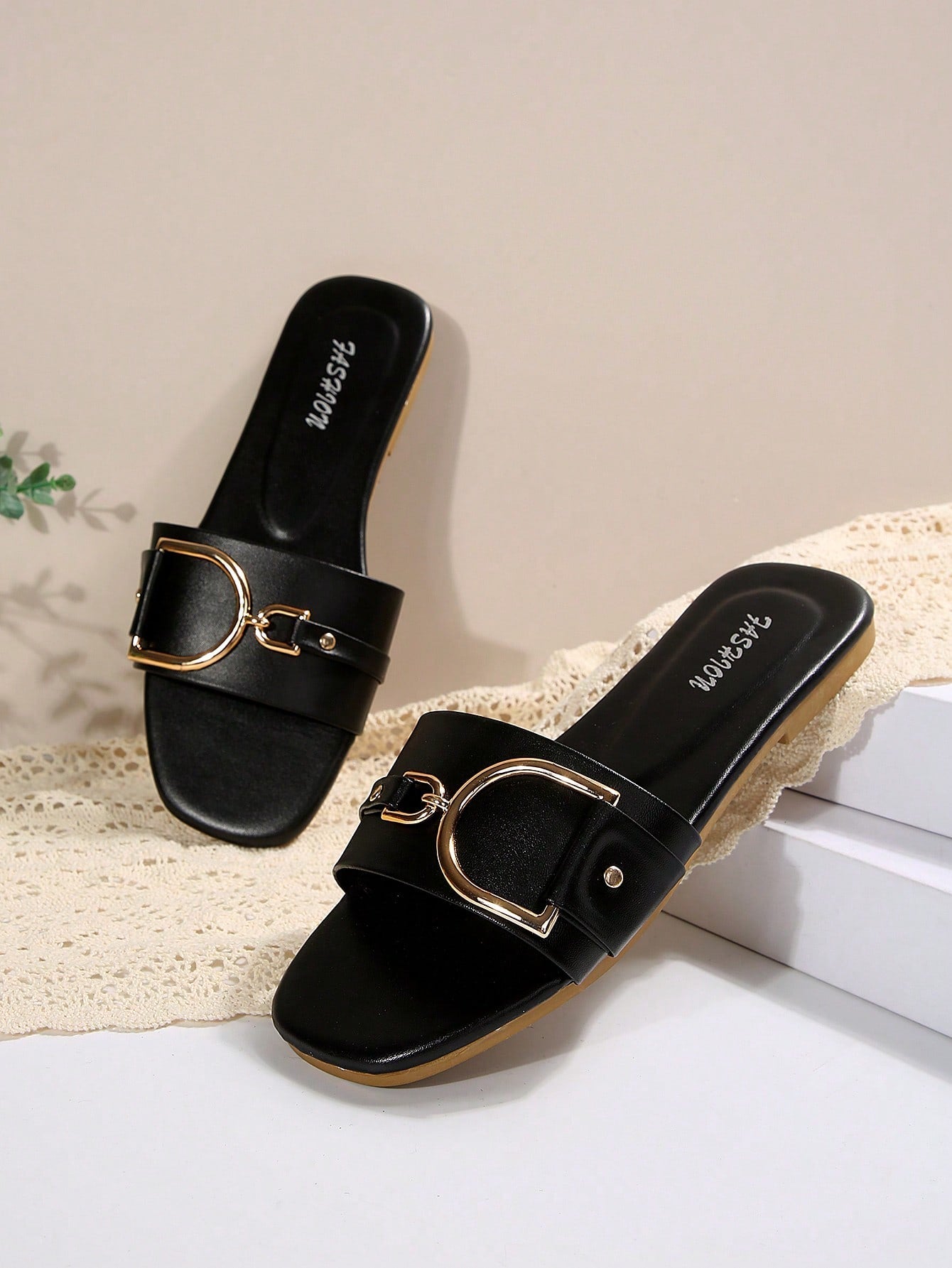 Pair of women’s wide fit flat slide sandals with an open toe, slip-on style, plain design, and gold buckle detail.