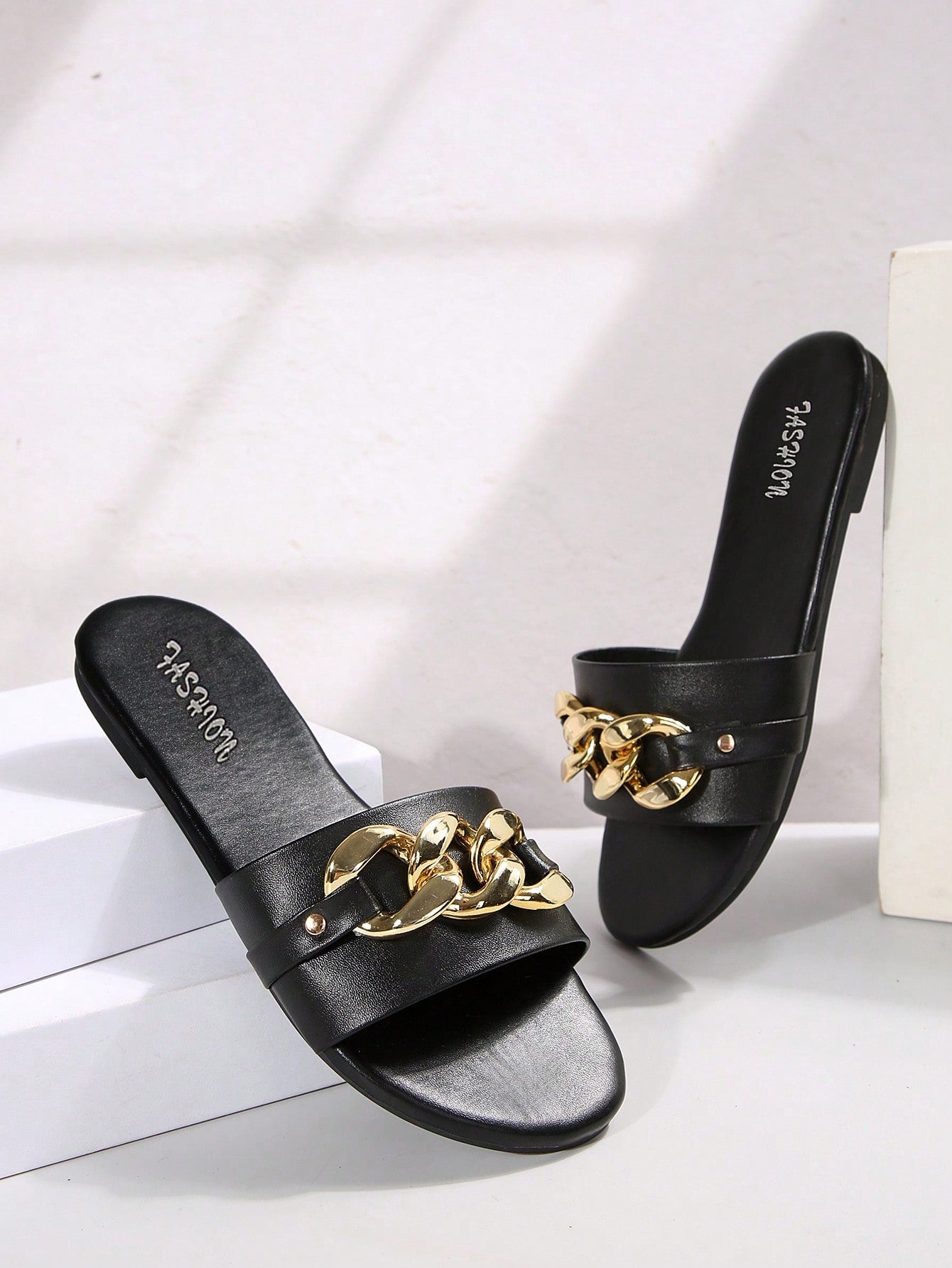 Pair of women's black flat slide sandals featuring rhinestone embellishments, metal accents, and a gold-strip detail on the upper, with an open-toe slip-on design.