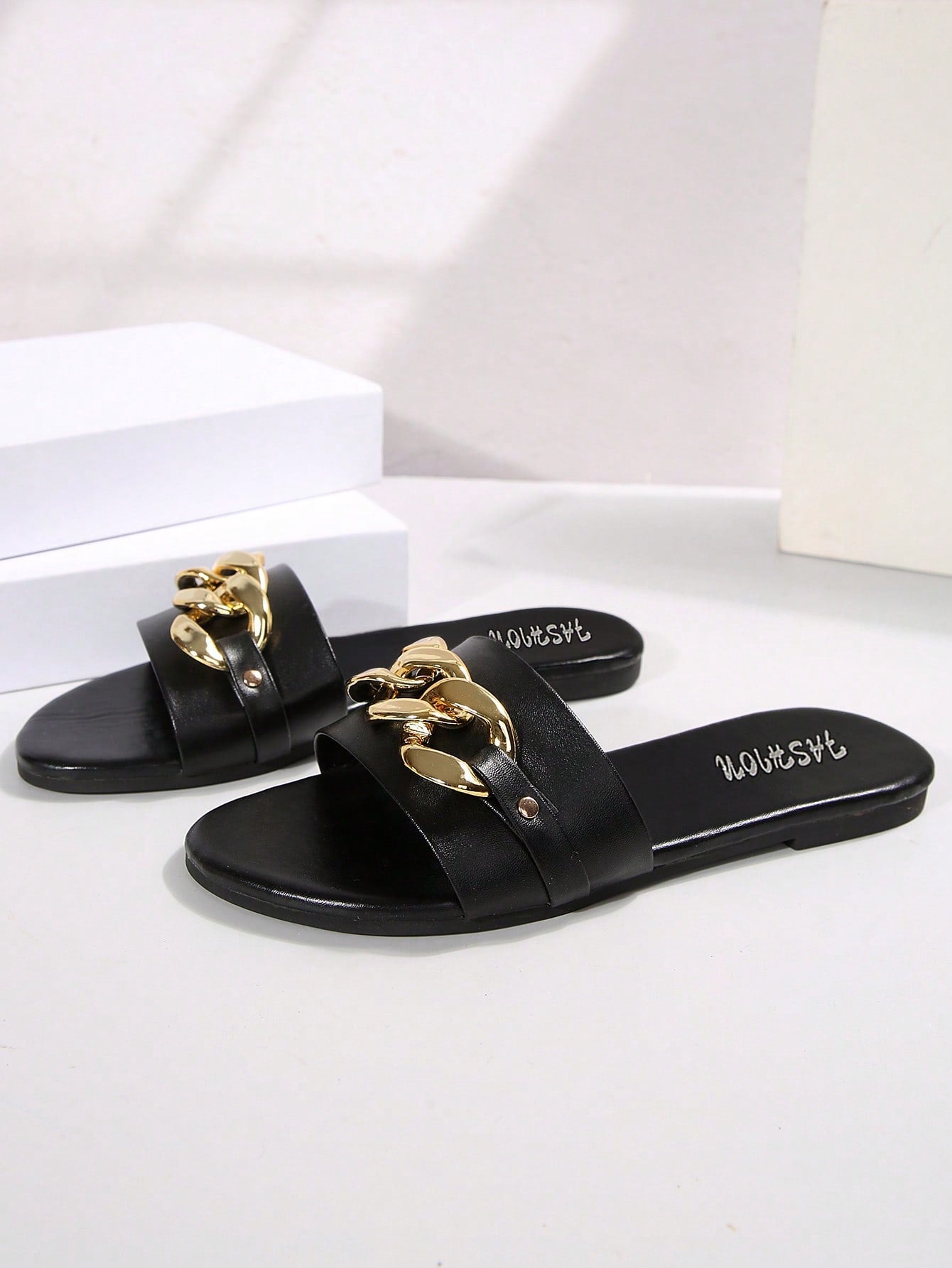 Pair of women's black flat slide sandals featuring rhinestone embellishments, metal accents, and a gold-strip detail on the upper, with an open-toe slip-on design.