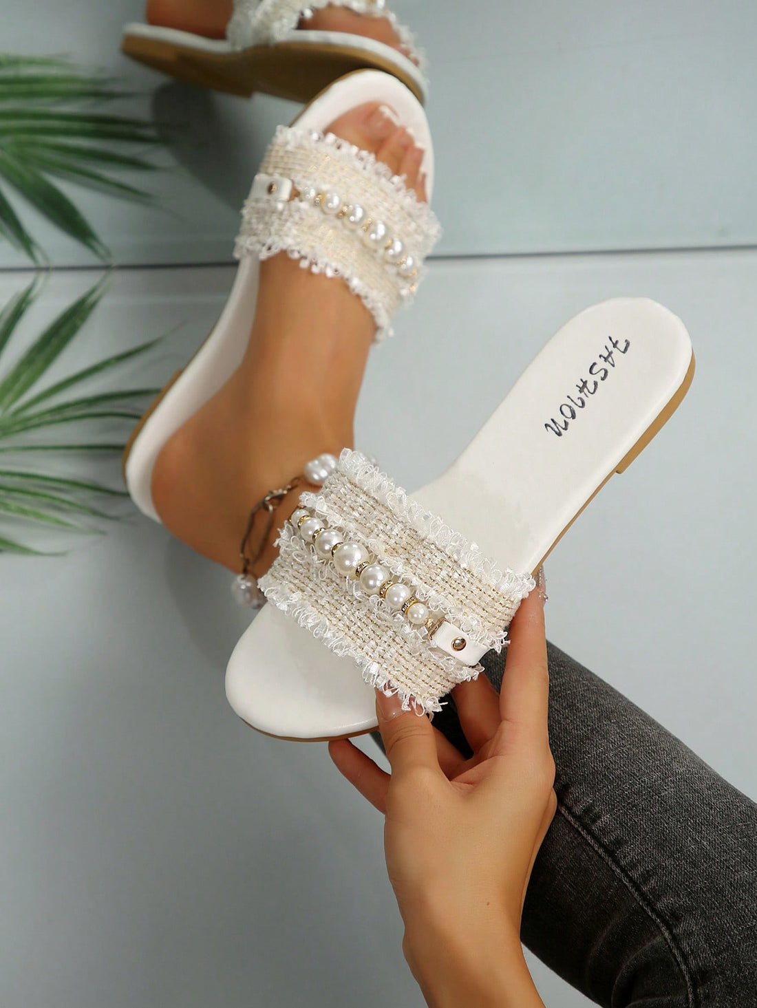 Women's flat open-toe slide sandals featuring pearl chain and rhinestone decor in a beach style.