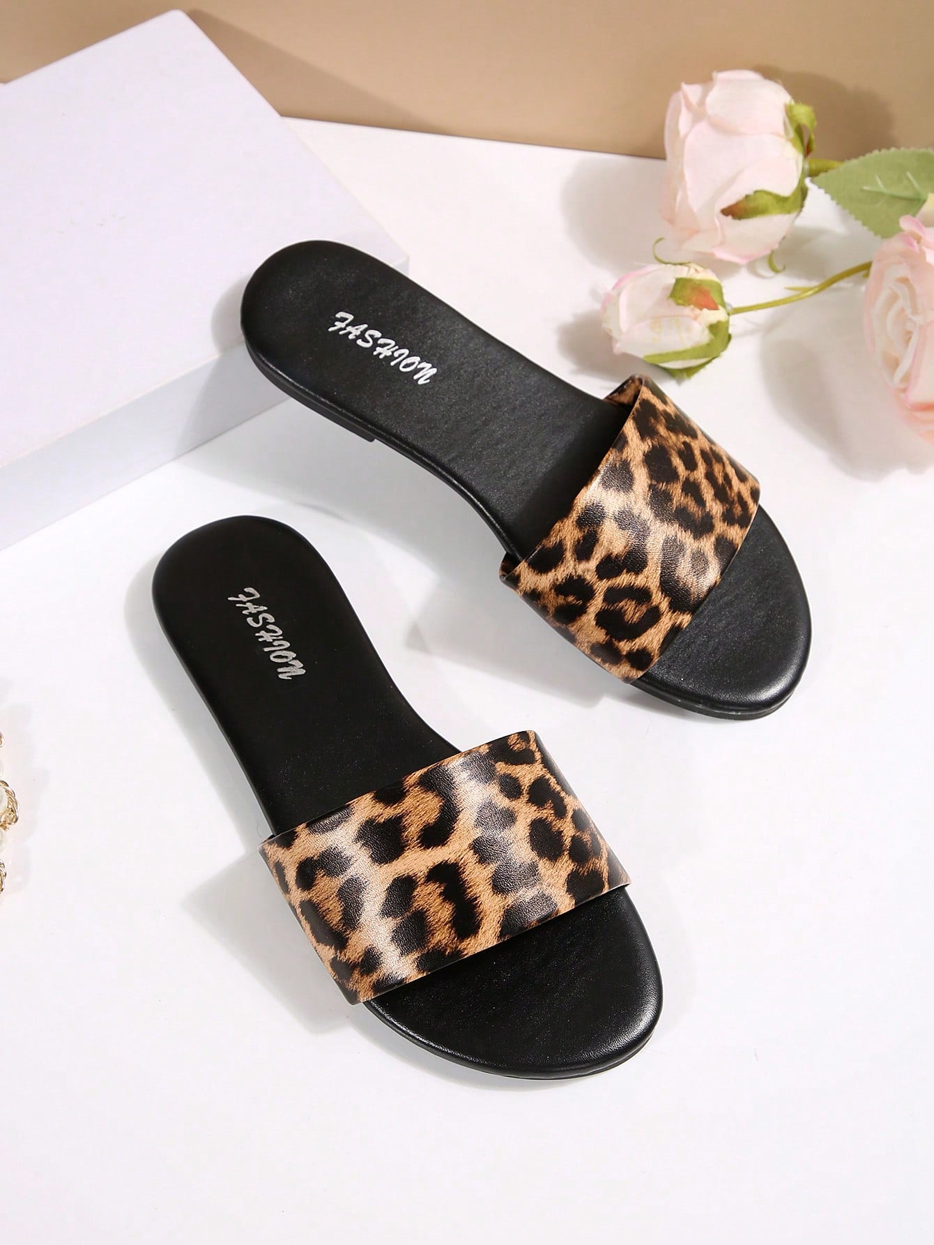 Pair of women's black flat slide sandals featuring rhinestone embellishments, metal accents, and a gold-strip detail on the upper, with an open-toe slip-on design.