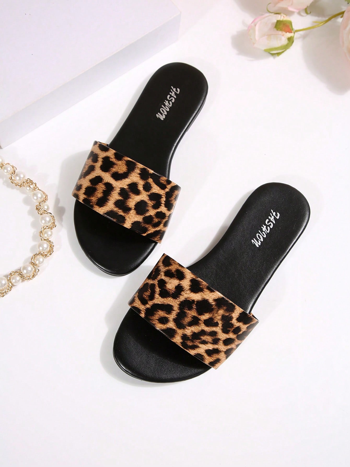Pair of women's black flat slide sandals featuring rhinestone embellishments, metal accents, and a gold-strip detail on the upper, with an open-toe slip-on design.