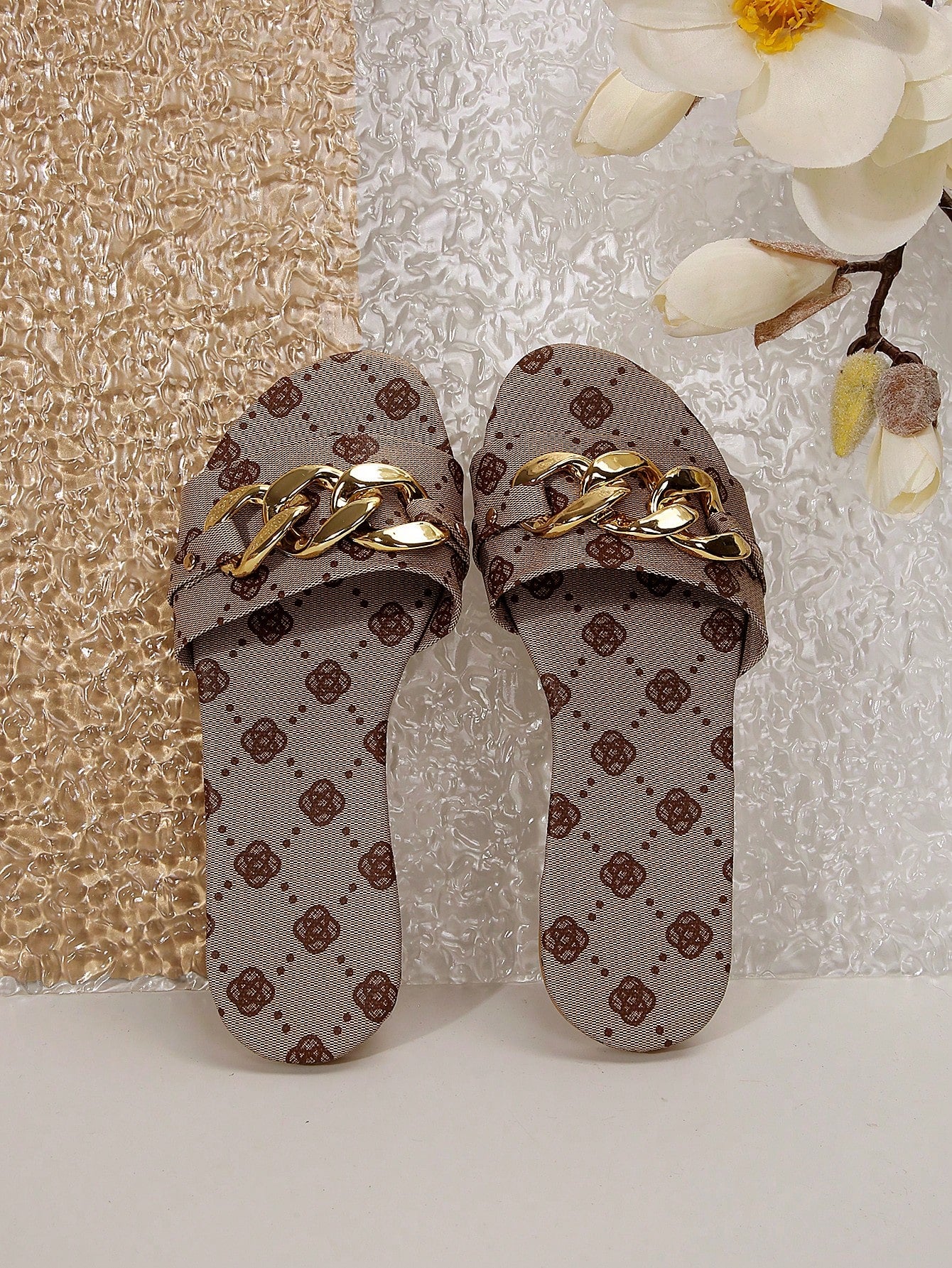 Pair of women's black flat slide sandals featuring rhinestone embellishments, metal accents, and a gold-strip detail on the upper, with an open-toe slip-on design.