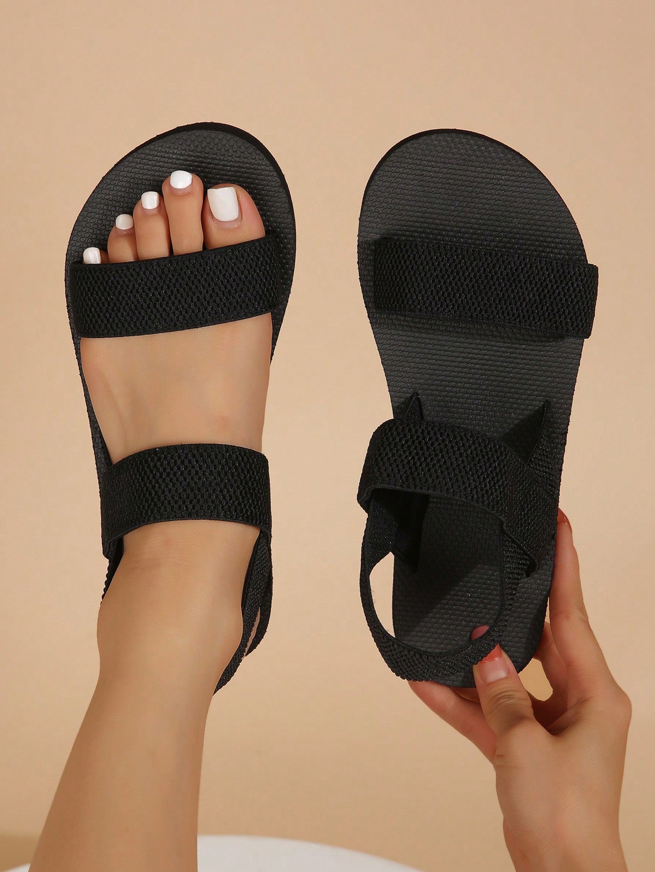 Women's black open-toe flat slide sandals with criss cross straps in a casual slip-on style for daily wear and beach travel.