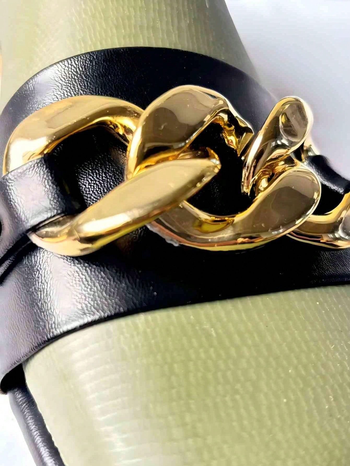 Pair of women's black flat slide sandals featuring rhinestone embellishments, metal accents, and a gold-strip detail on the upper, with an open-toe slip-on design.