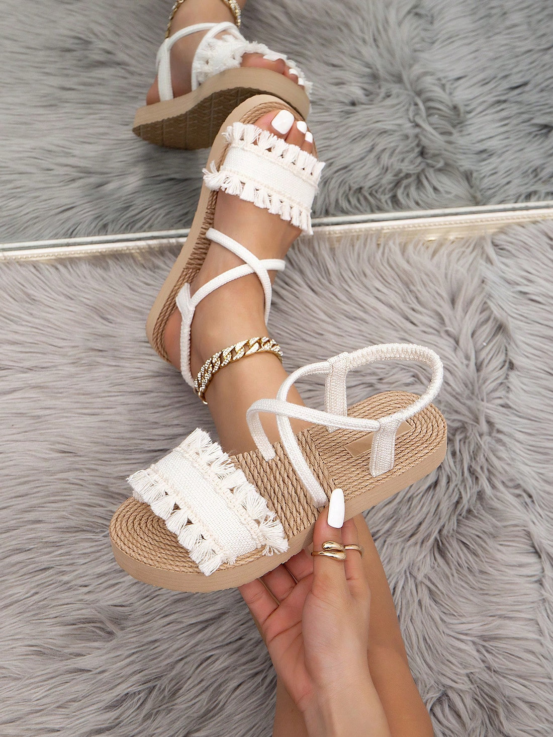 Women's white open-toe flat slide sandals featuring ruched fabric, bow accent, and fringe detail in a minimalist retro style.