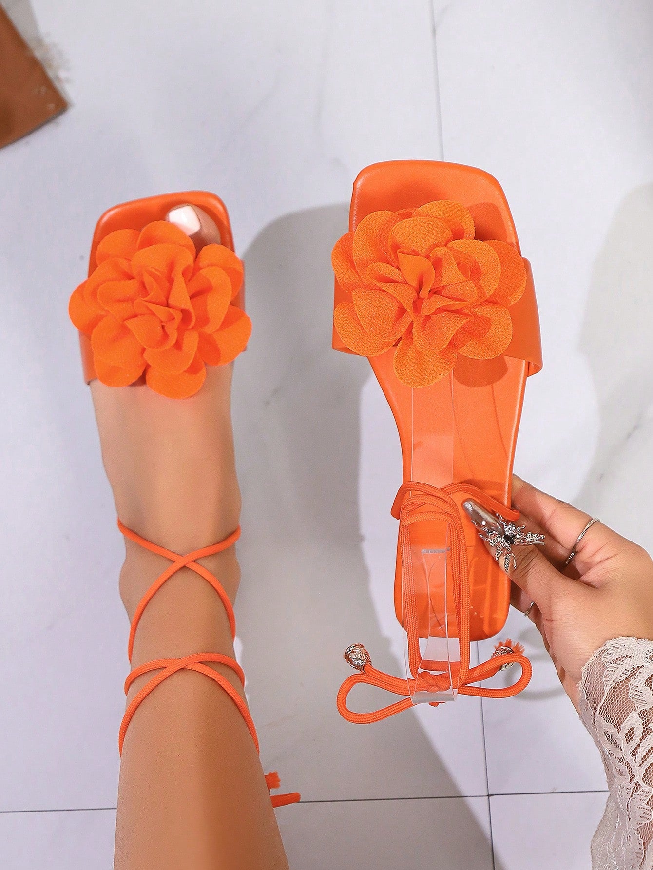 Women's flat strappy sandals with bow detail, open toe, and Roman-style criss-cross lace-up design in an elegant look.