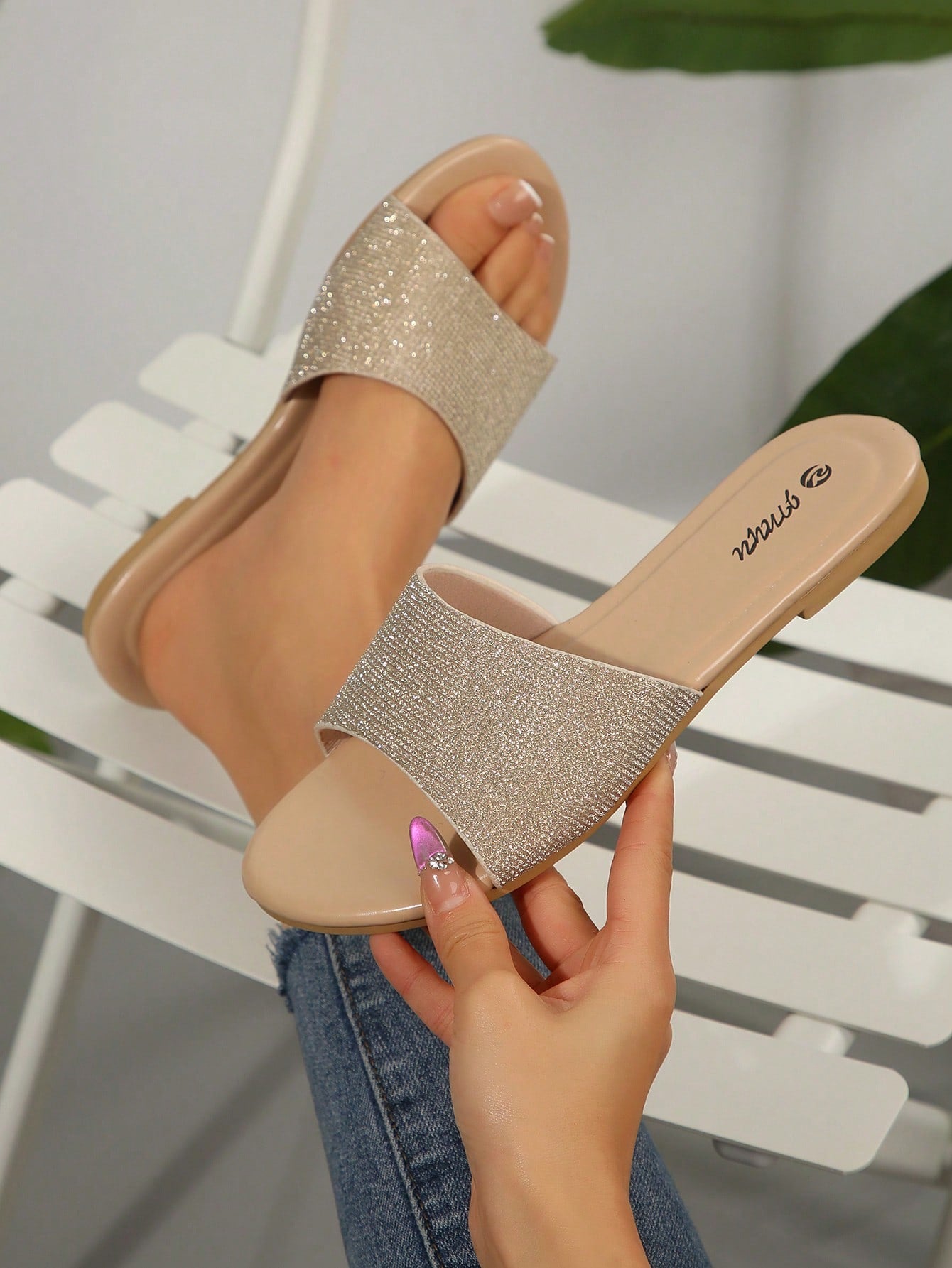 Pair of women's black flat slide sandals featuring rhinestone embellishments, metal accents, and a gold-strip detail on the upper, with an open-toe slip-on design.
