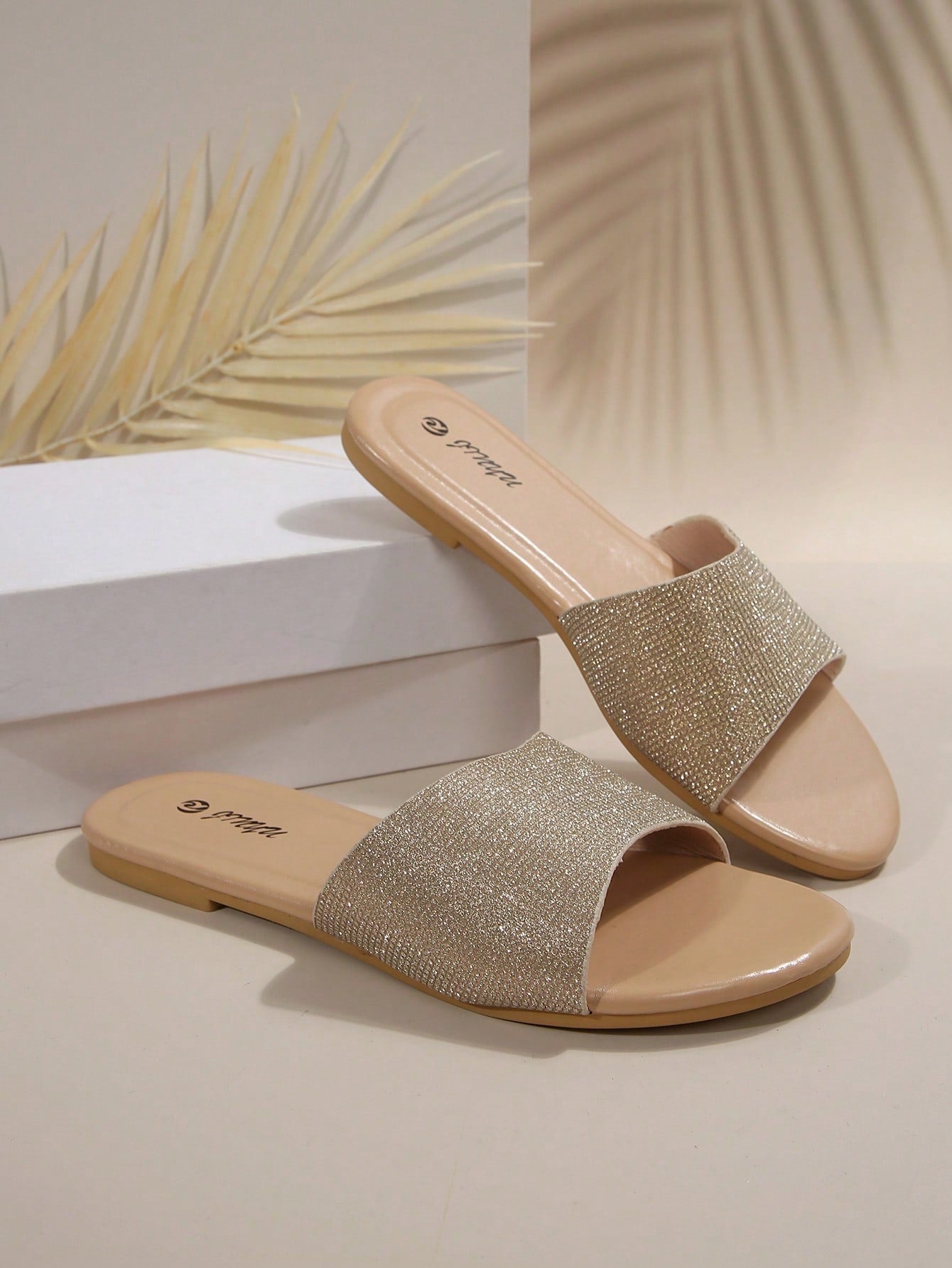 Pair of women's black flat slide sandals featuring rhinestone embellishments, metal accents, and a gold-strip detail on the upper, with an open-toe slip-on design.