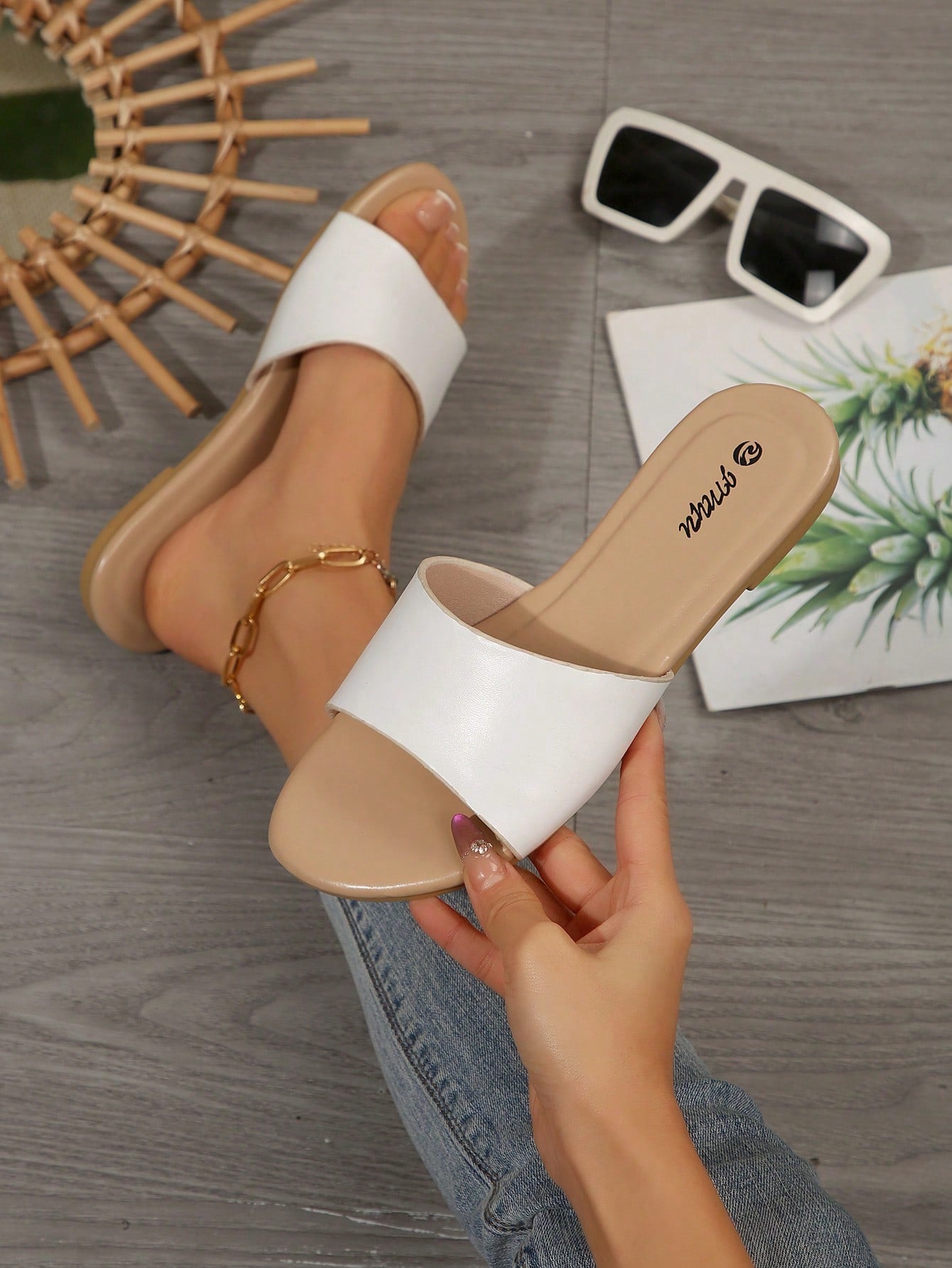 Pair of women's black flat slide sandals featuring rhinestone embellishments, metal accents, and a gold-strip detail on the upper, with an open-toe slip-on design.