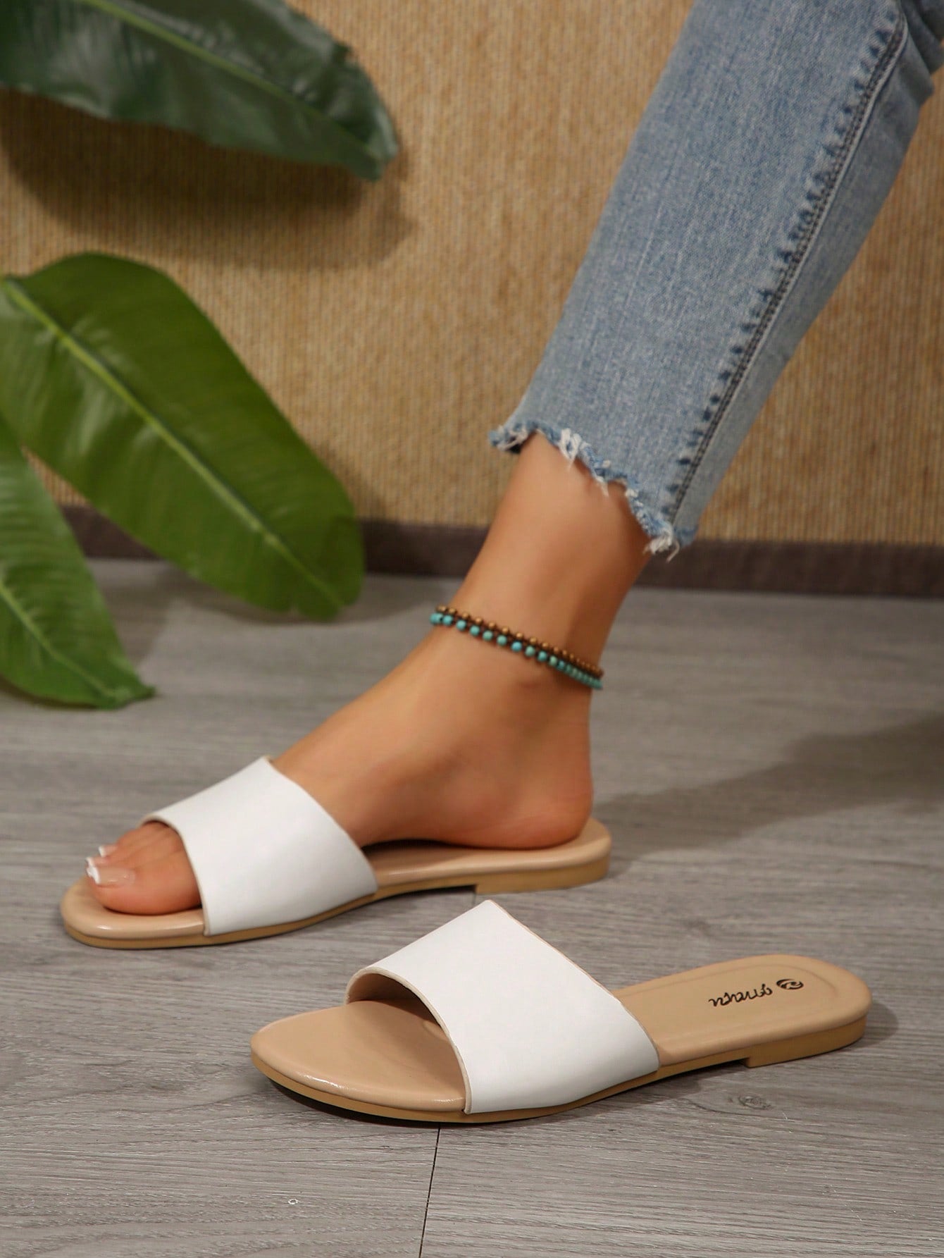 Pair of women's black flat slide sandals featuring rhinestone embellishments, metal accents, and a gold-strip detail on the upper, with an open-toe slip-on design.