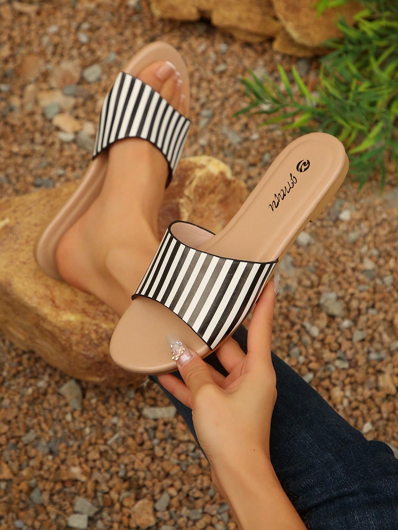 Pair of women's black flat slide sandals featuring rhinestone embellishments, metal accents, and a gold-strip detail on the upper, with an open-toe slip-on design.