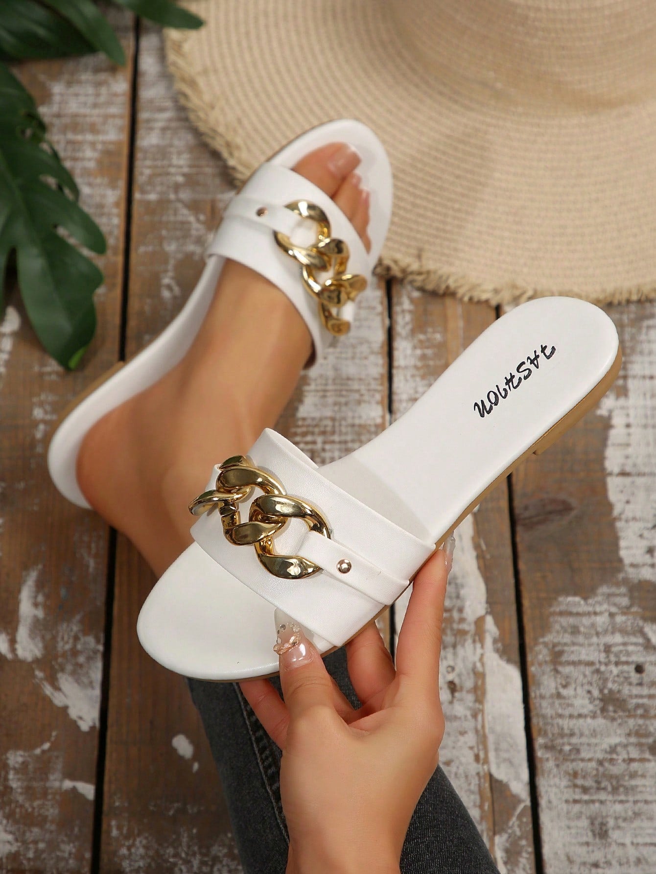 Pair of women's black flat slide sandals featuring rhinestone embellishments, metal accents, and a gold-strip detail on the upper, with an open-toe slip-on design.