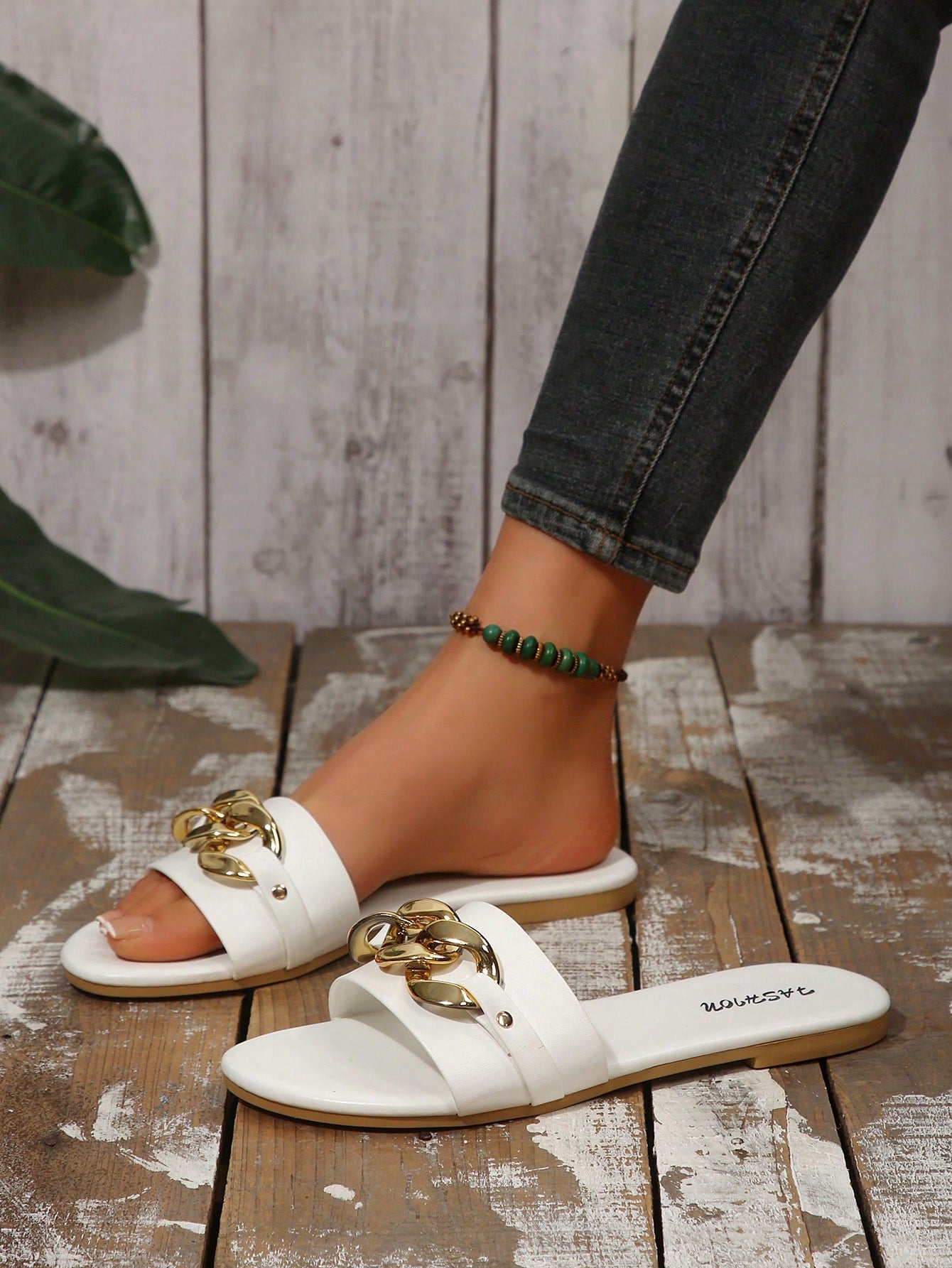 Pair of women's black flat slide sandals featuring rhinestone embellishments, metal accents, and a gold-strip detail on the upper, with an open-toe slip-on design.