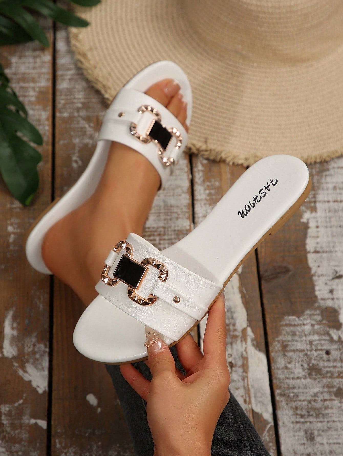 Pair of women's black flat slide sandals featuring rhinestone embellishments, metal accents, and a gold-strip detail on the upper, with an open-toe slip-on design.