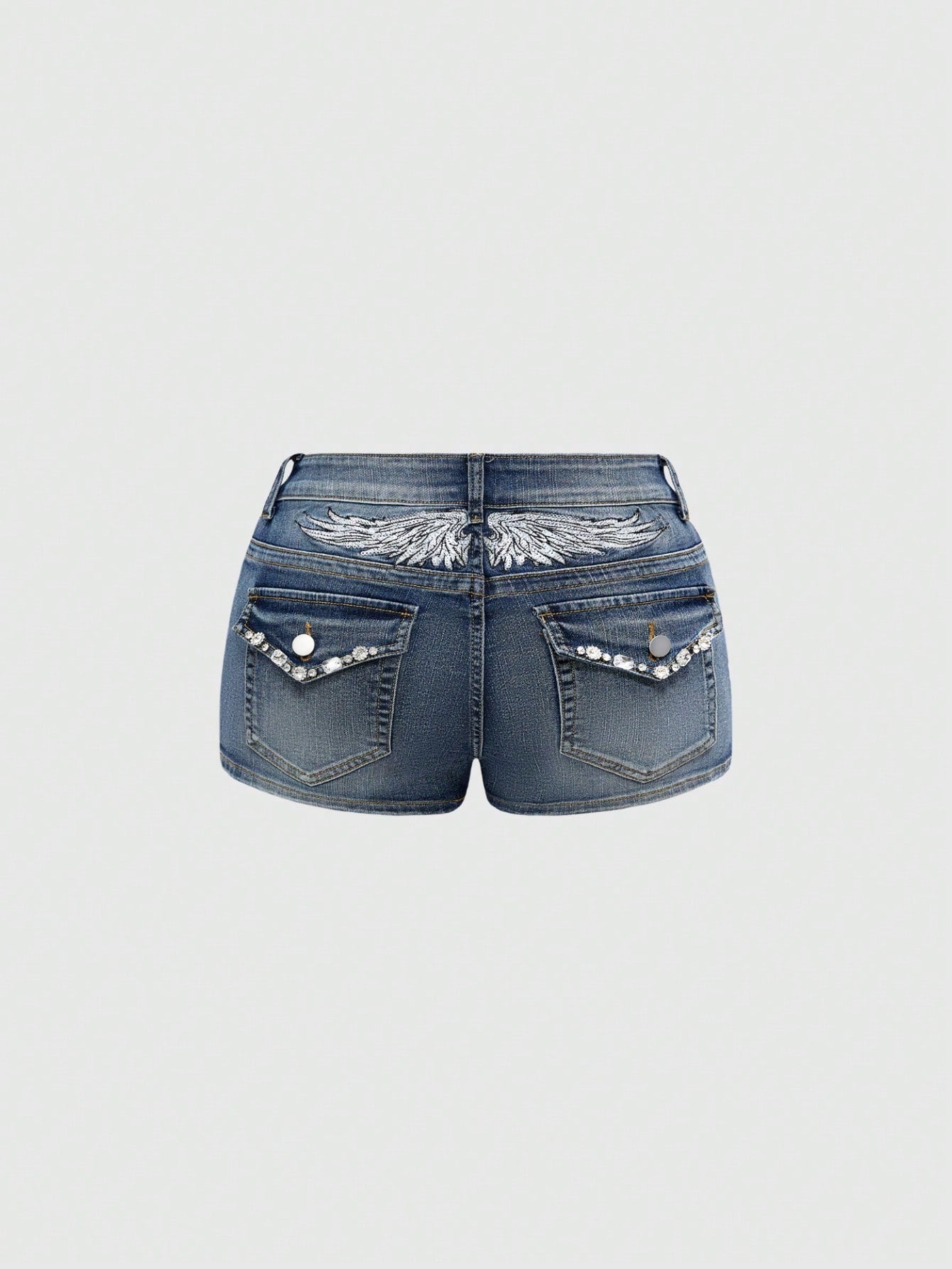 Blue ultra low waist mini shorts with ripped details, zipper fly, button closure, back wing embroidery, and rhinestone decor in a Y2K grunge punk style.