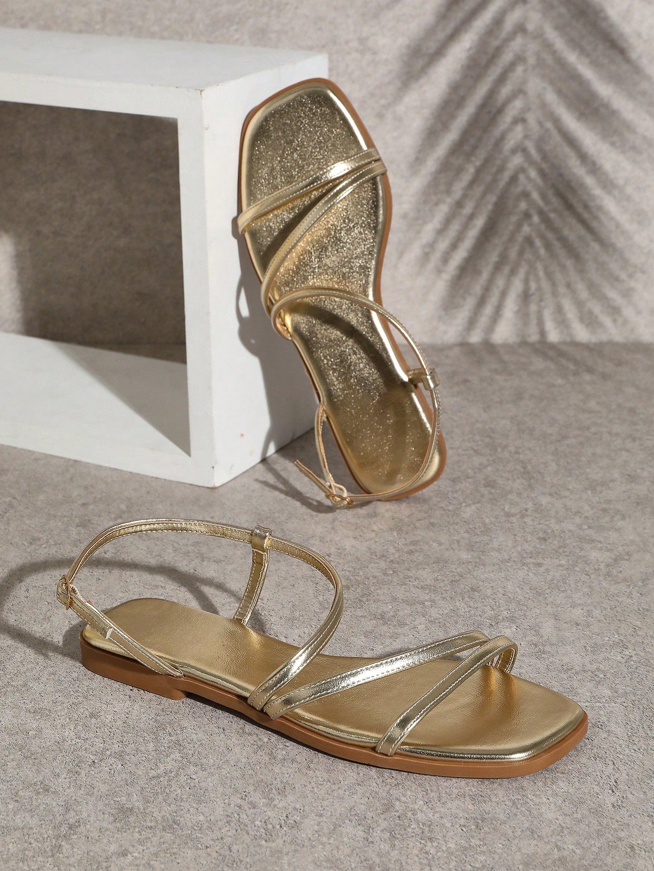 Women's flat open-toe sandals featuring a buckle detail and PU leather construction with a flat sole.
