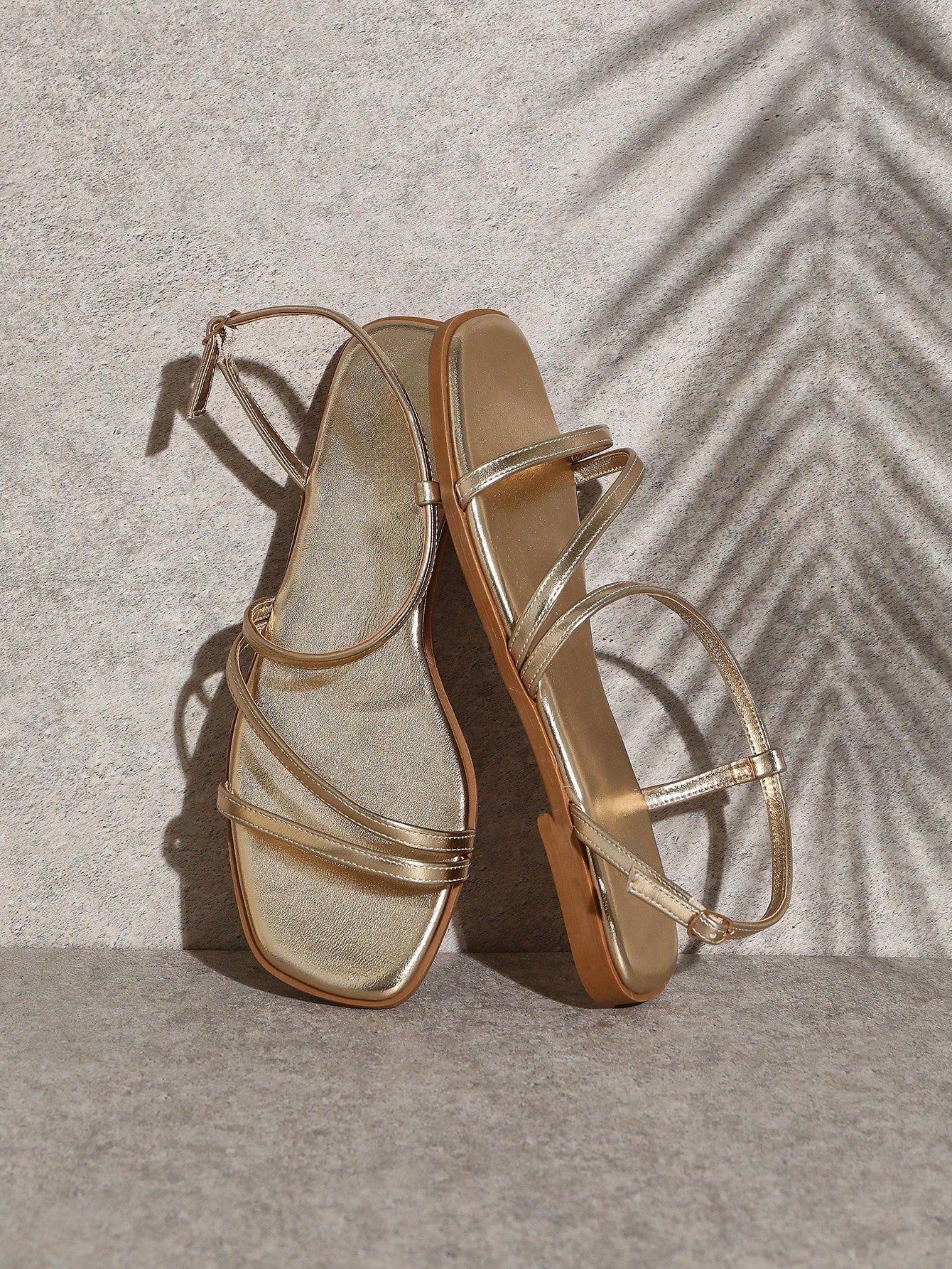 Women's flat open-toe sandals featuring a buckle detail and PU leather construction with a flat sole.