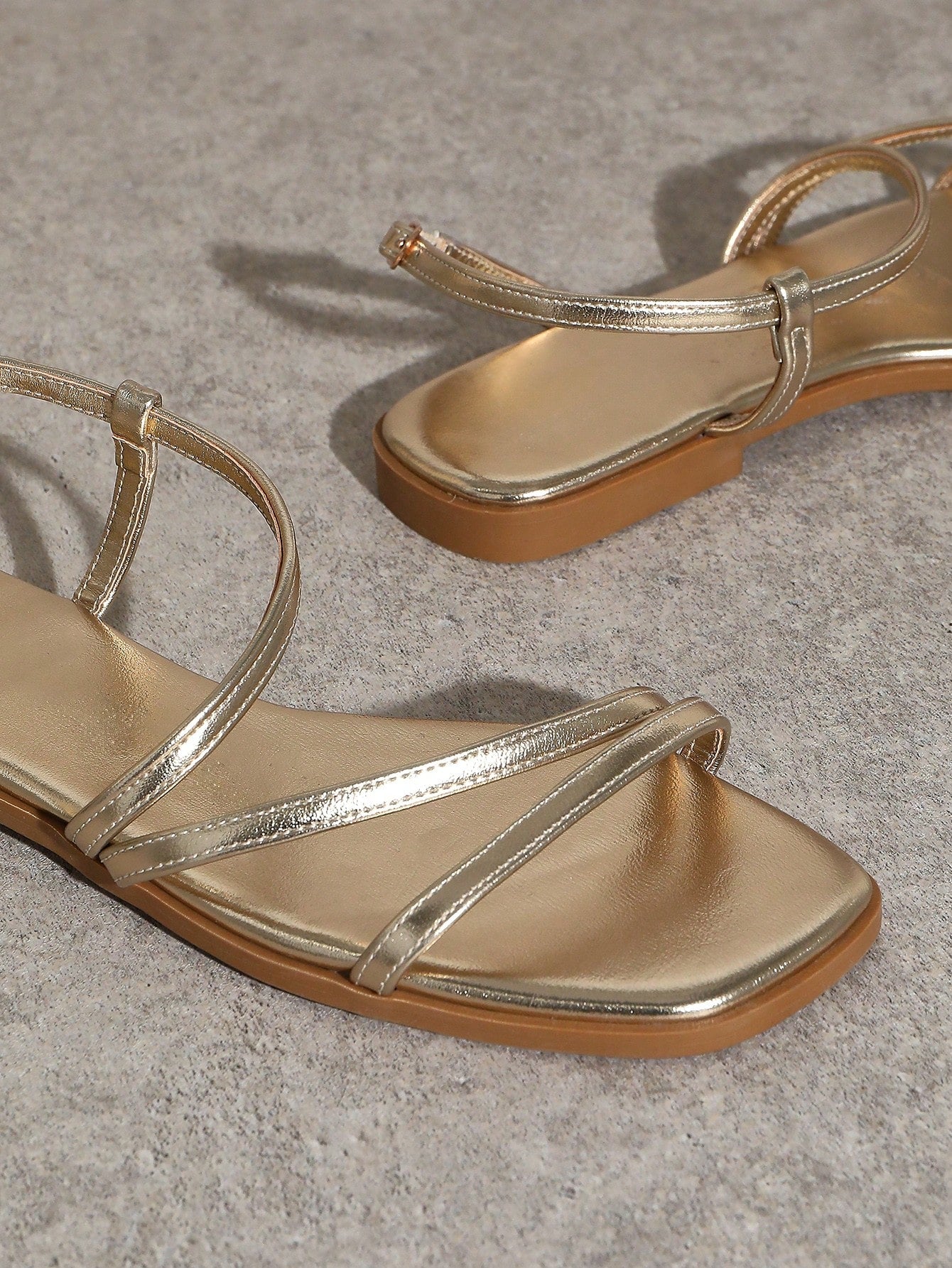 Women's flat open-toe sandals featuring a buckle detail and PU leather construction with a flat sole.