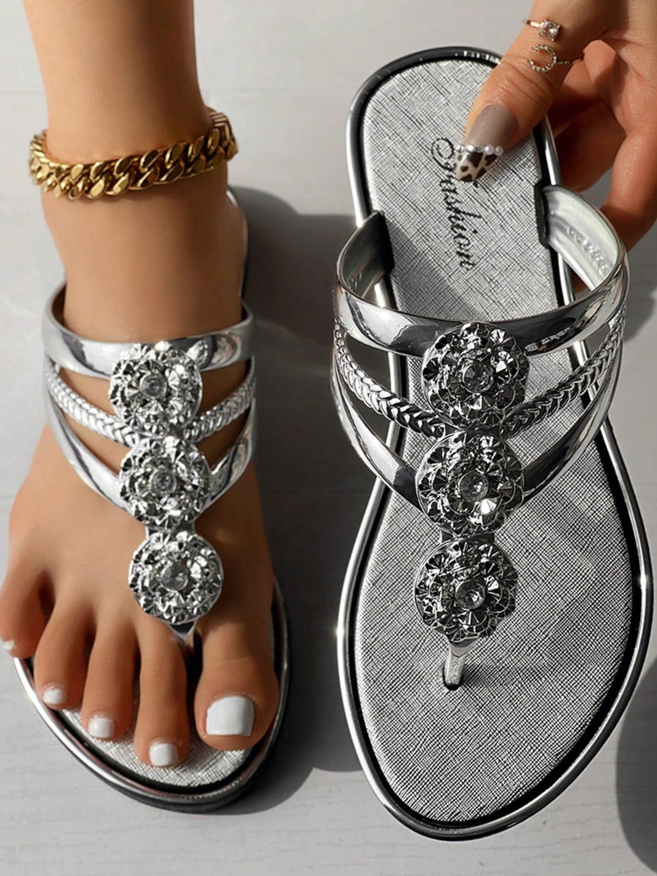 Women's gold metal-look open-toe strappy slide sandals with crystal floral rhinestone decor and flat sole, suitable for beach, vacation, and casual wear.