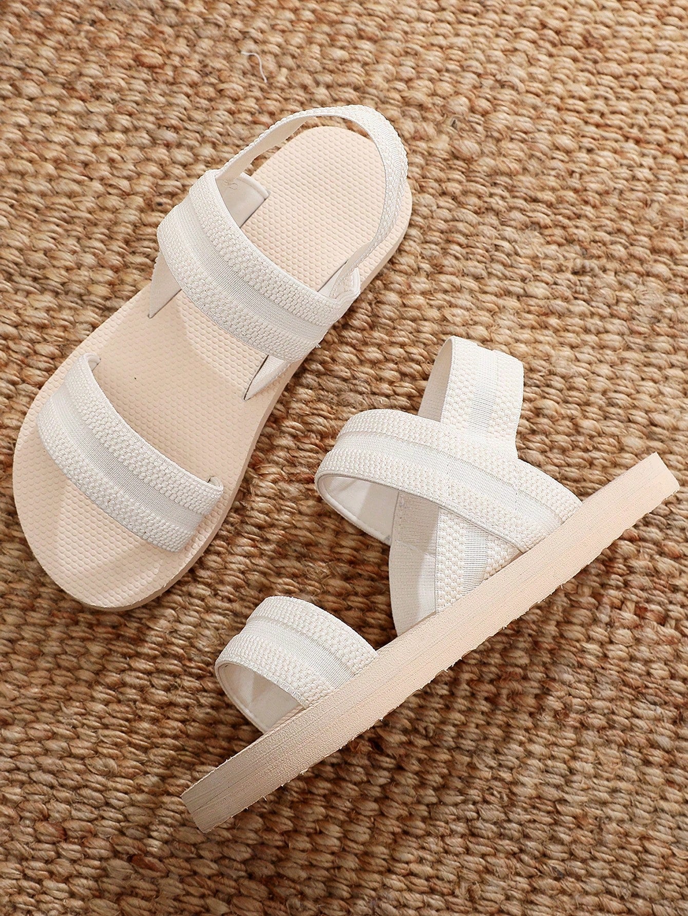 Women's black open-toe flat slide sandals with criss cross straps in a casual slip-on style for daily wear and beach travel.