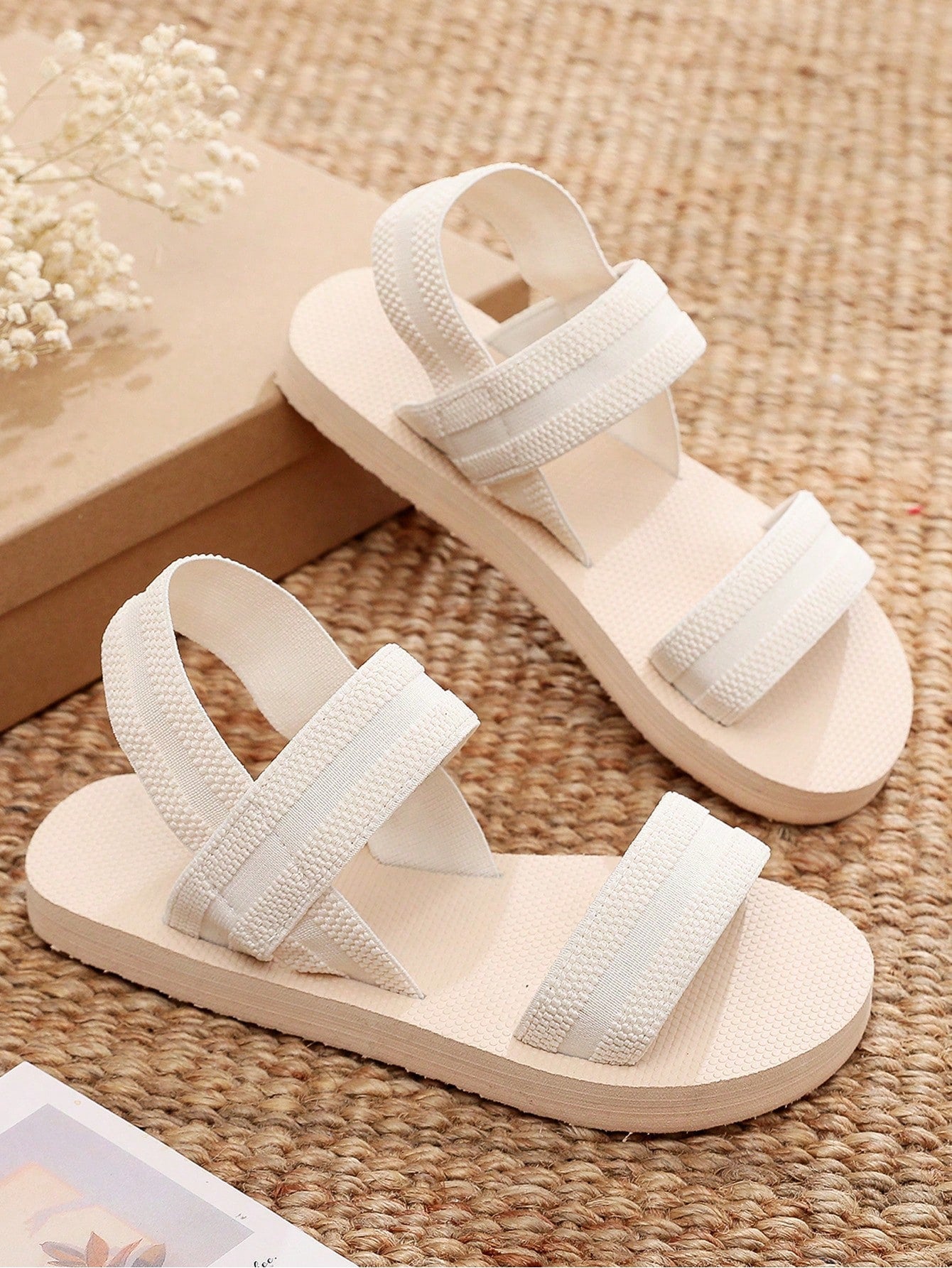 Women's black open-toe flat slide sandals with criss cross straps in a casual slip-on style for daily wear and beach travel.