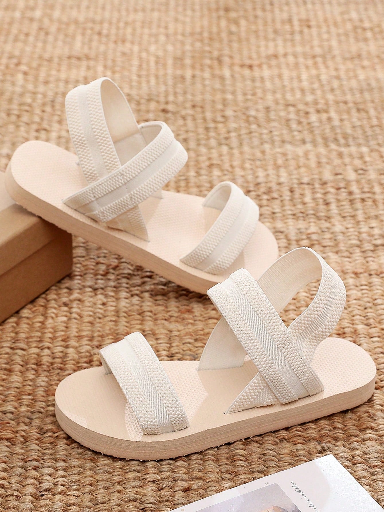 Women's black open-toe flat slide sandals with criss cross straps in a casual slip-on style for daily wear and beach travel.