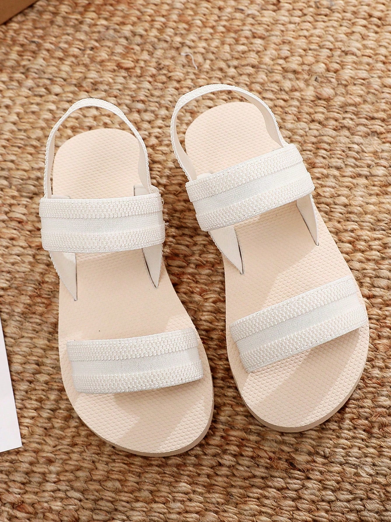 Women's black open-toe flat slide sandals with criss cross straps in a casual slip-on style for daily wear and beach travel.