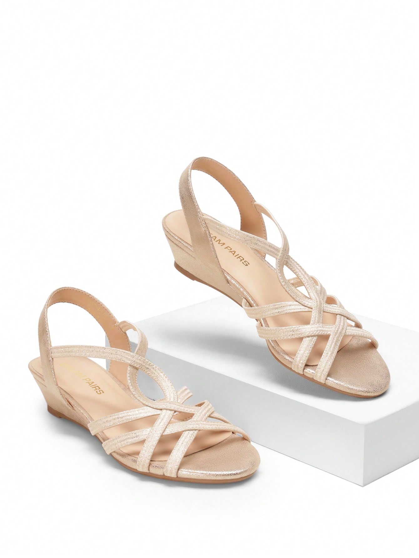 Women's open-toe low wedge sandals featuring crisscross straps, slingback ankle strap, and a classic wedge heel for dressy and everyday summer outfits.