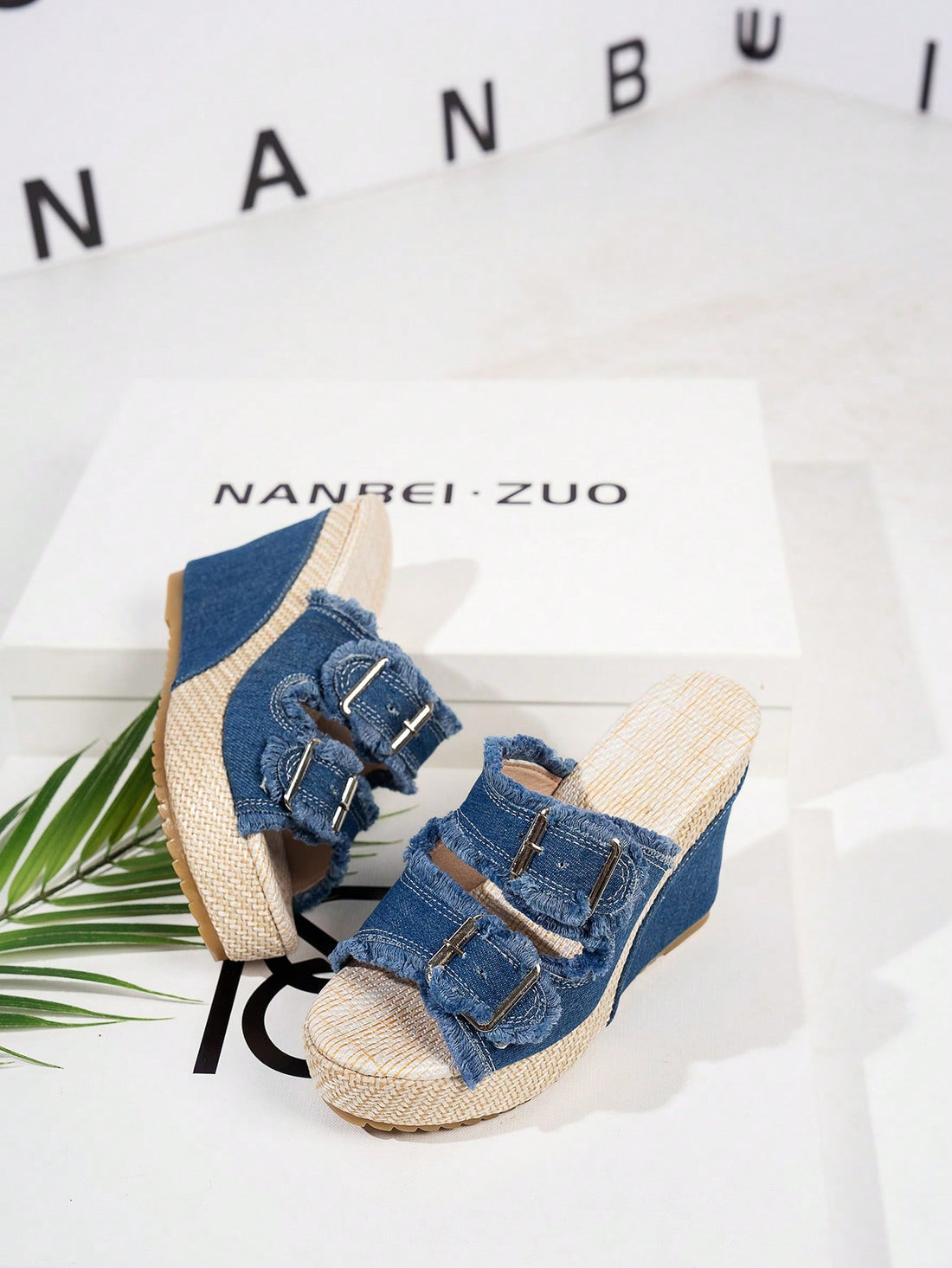 Women’s blue open-toe wedge slide sandals with buckle detail and high wedge heel, slip-on style with thick sole.