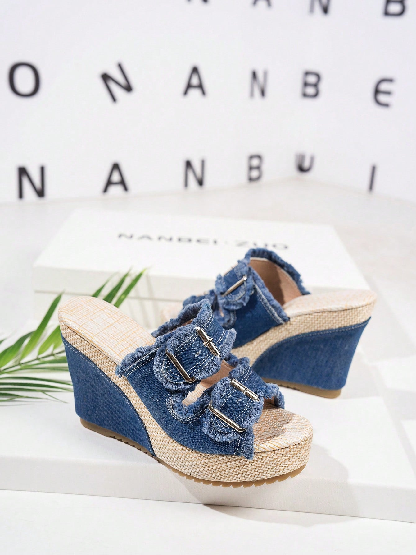 Women’s blue open-toe wedge slide sandals with buckle detail and high wedge heel, slip-on style with thick sole.