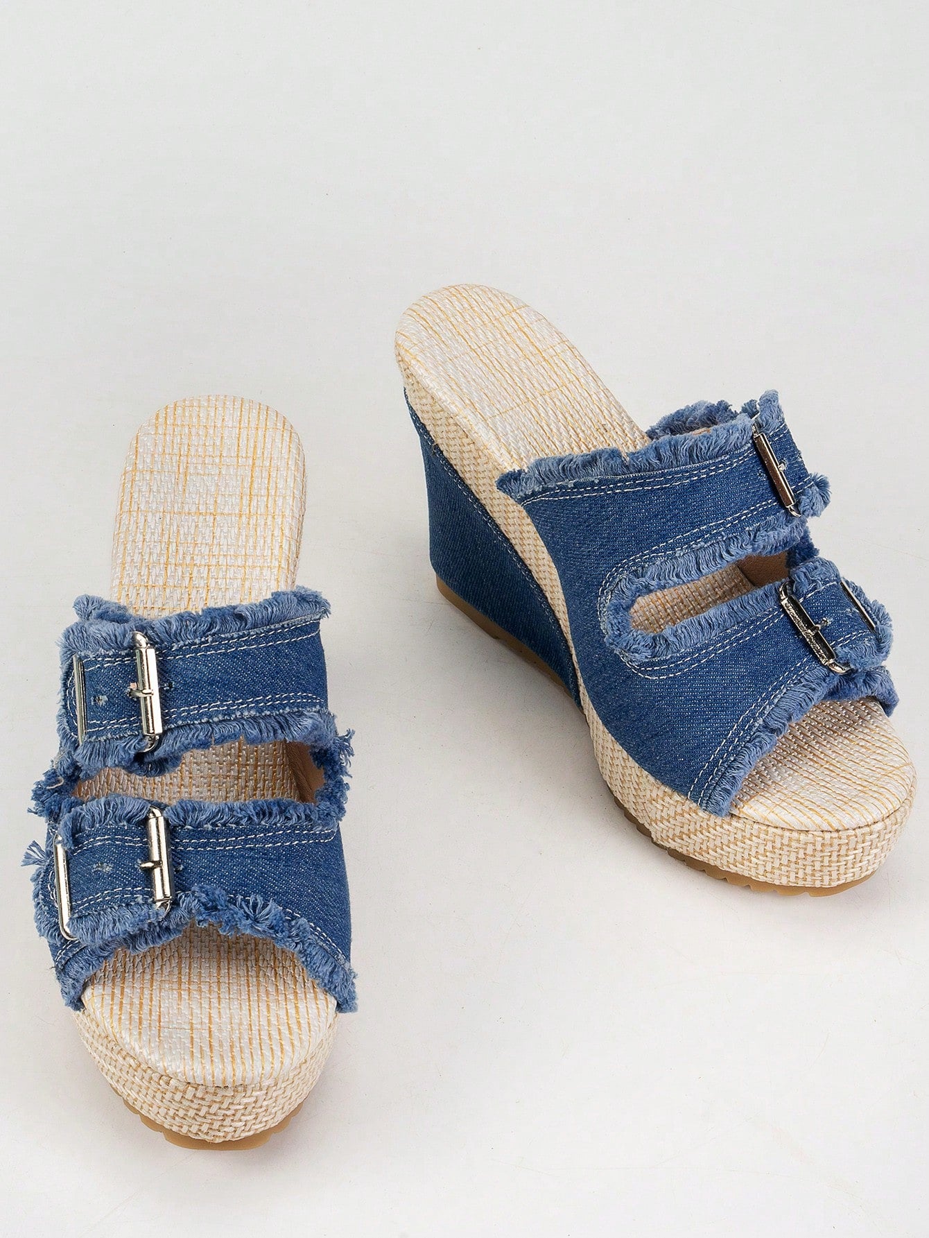 Women’s blue open-toe wedge slide sandals with buckle detail and high wedge heel, slip-on style with thick sole.