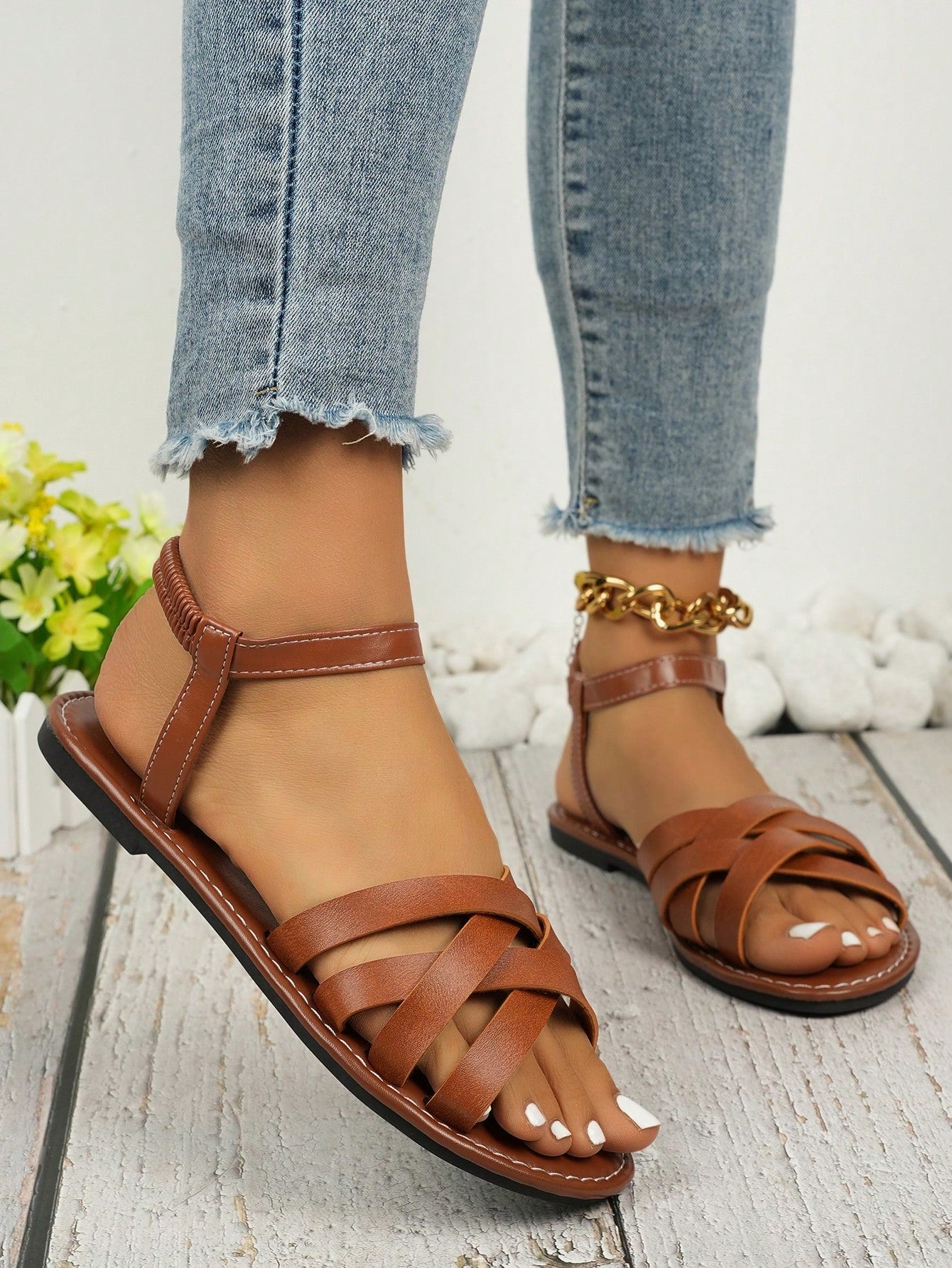 Women's black flat gladiator sandals with an open toe, criss-cross lace-up front, and buckle detail.