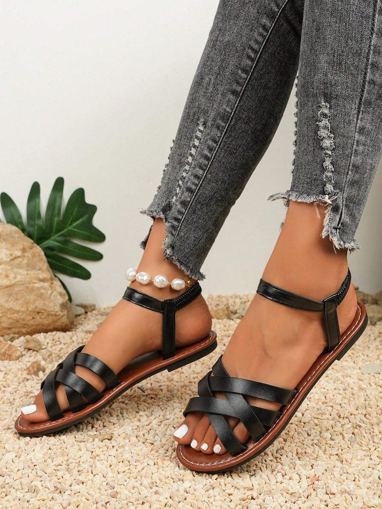 Women's black flat gladiator sandals with an open toe, criss-cross lace-up front, and buckle detail.