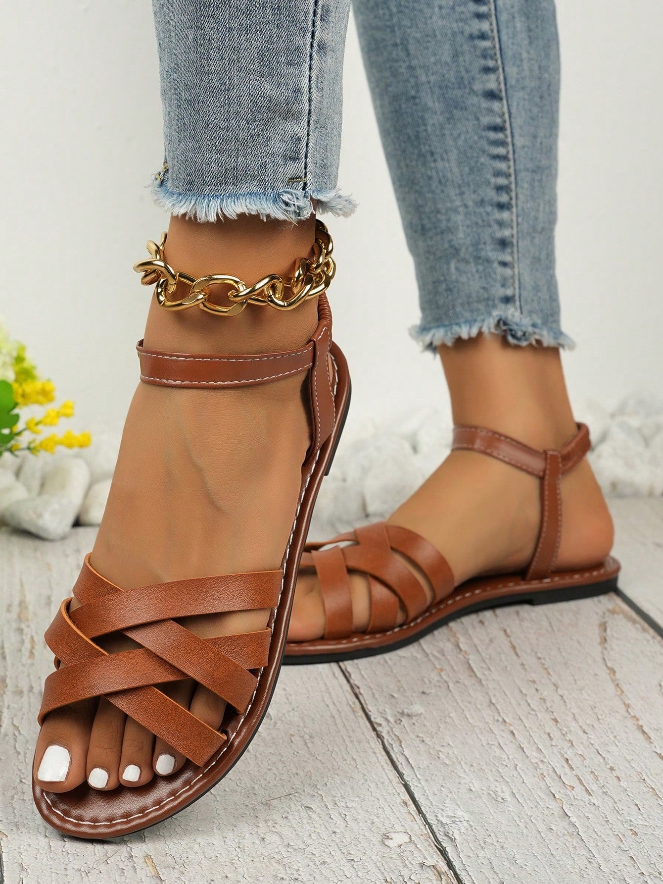 Women's black flat gladiator sandals with an open toe, criss-cross lace-up front, and buckle detail.