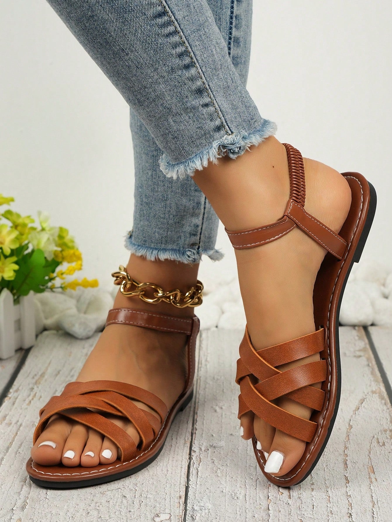 Women's black flat gladiator sandals with an open toe, criss-cross lace-up front, and buckle detail.