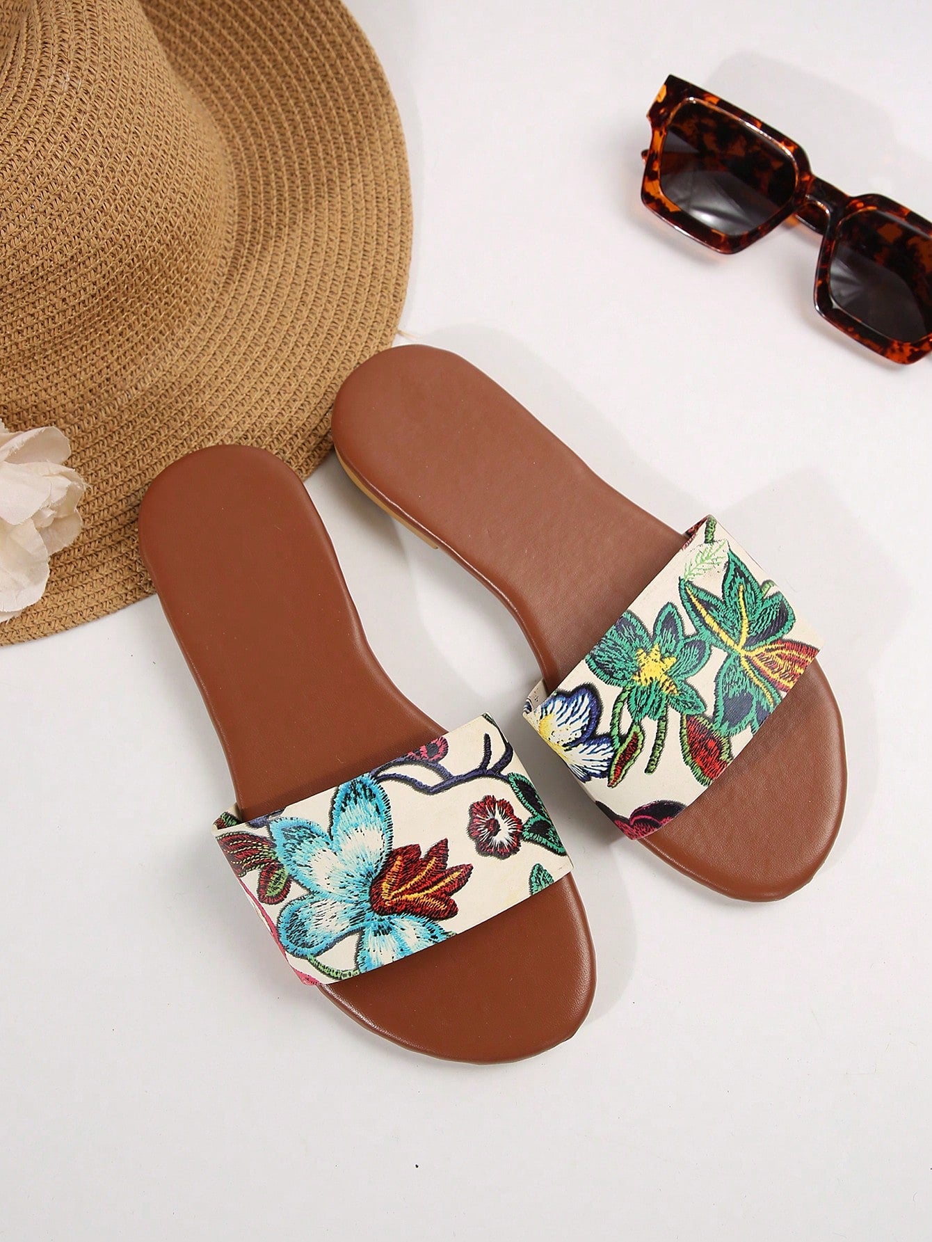 Pair of women's black flat slide sandals featuring rhinestone embellishments, metal accents, and a gold-strip detail on the upper, with an open-toe slip-on design.