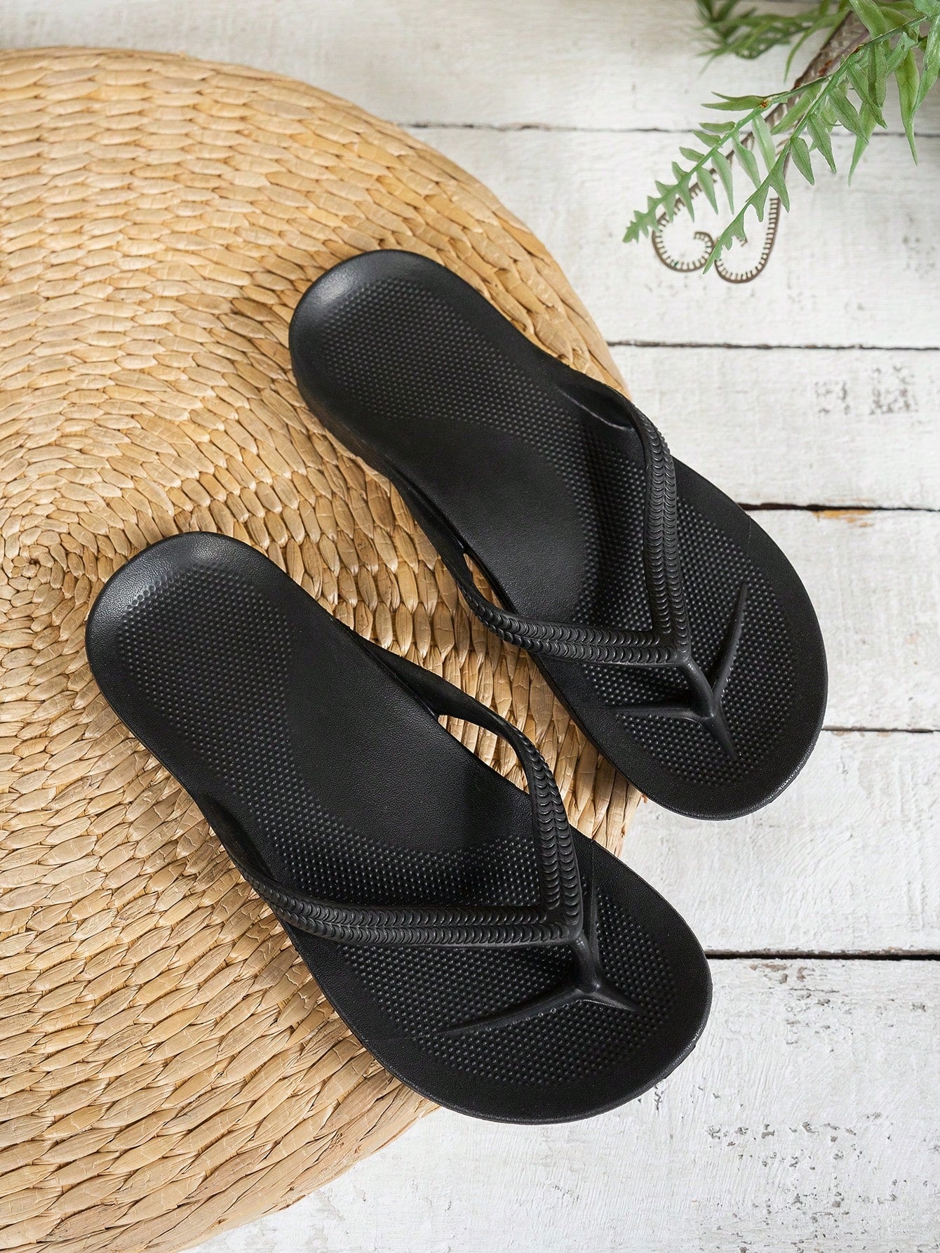 Women's solid color flip flops with open-toe design, flat sole, and cut-out details, suitable for casual indoor or outdoor wear at the beach or pool.
