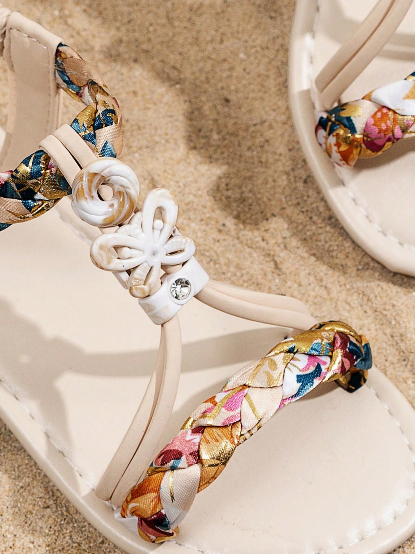 Beige kids slip-on slingback flat sandals with open toe, pearl and rhinestone embellishments, and plant pattern detail.