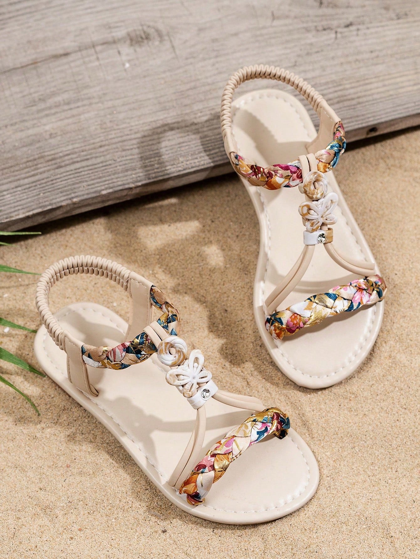 Beige kids slip-on slingback flat sandals with open toe, pearl and rhinestone embellishments, and plant pattern detail.
