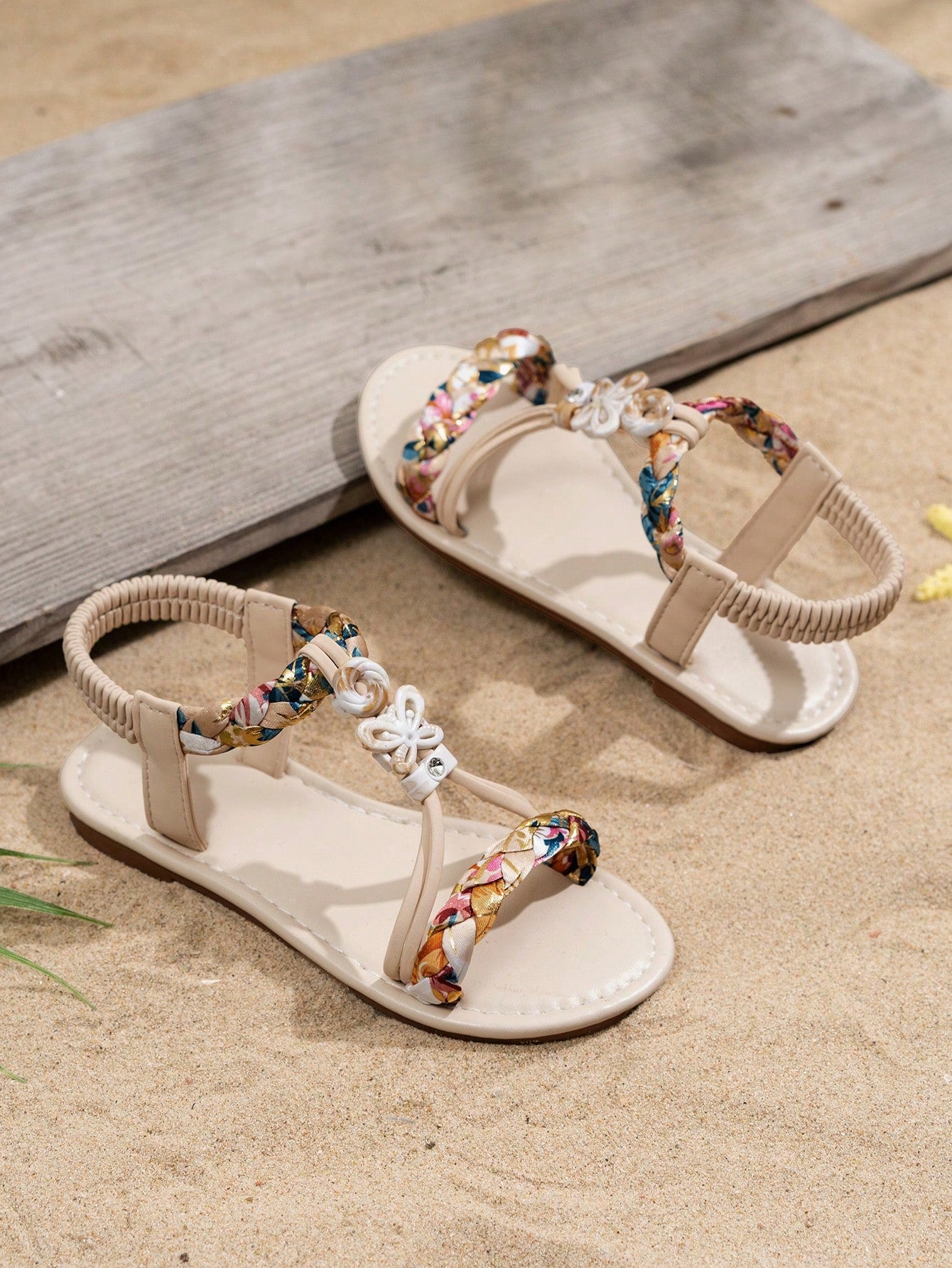 Beige kids slip-on slingback flat sandals with open toe, pearl and rhinestone embellishments, and plant pattern detail.