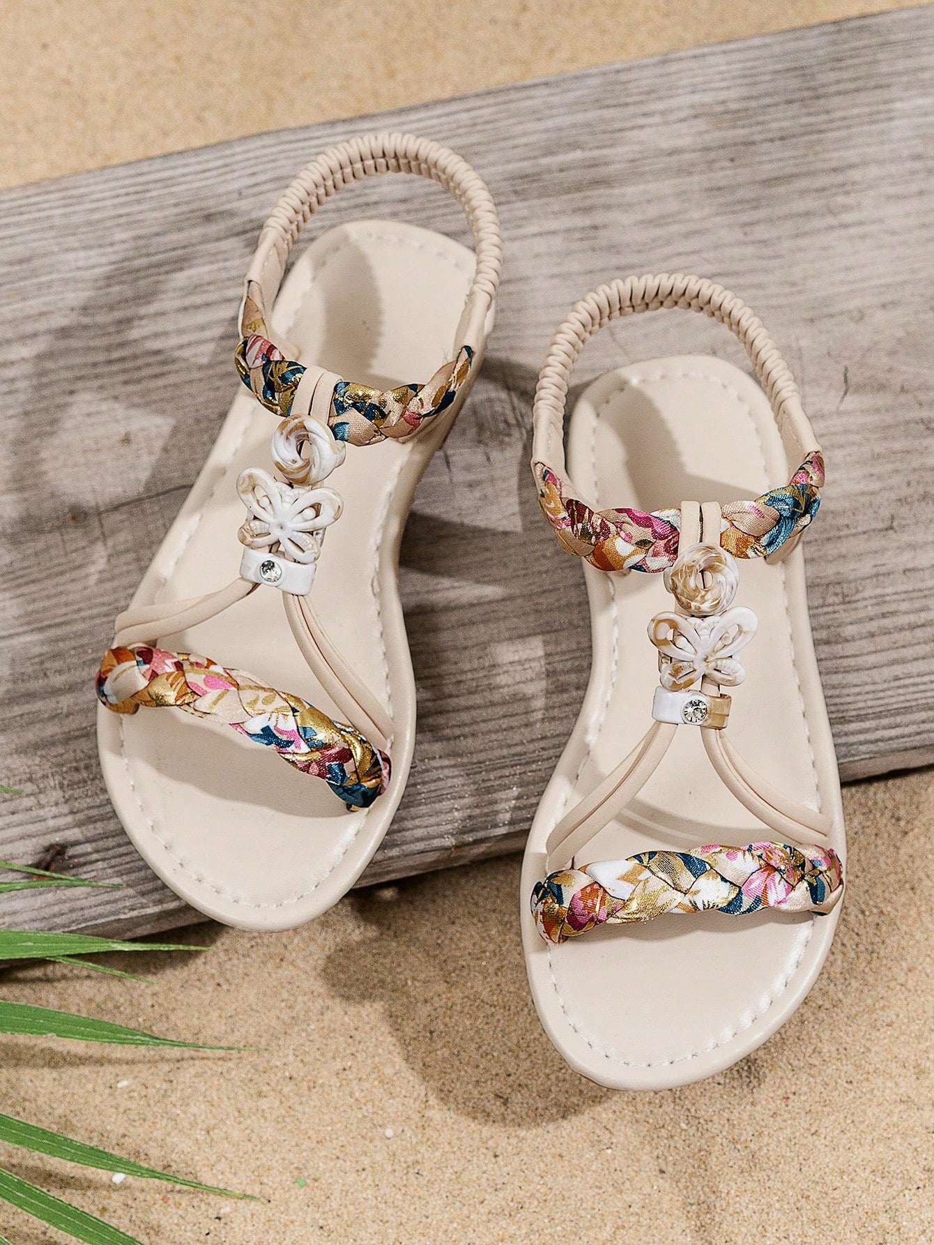 Beige kids slip-on slingback flat sandals with open toe, pearl and rhinestone embellishments, and plant pattern detail.
