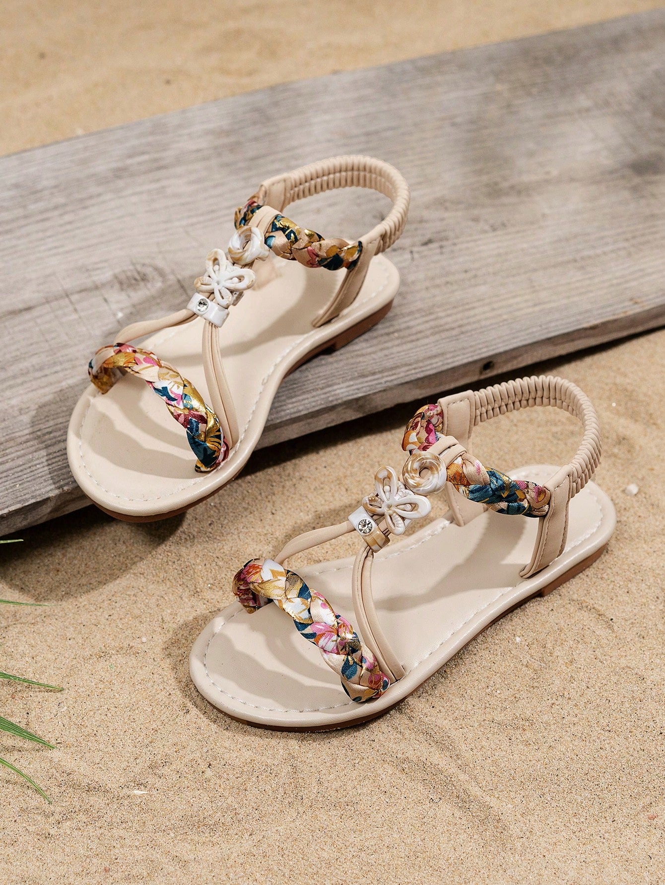 Beige kids slip-on slingback flat sandals with open toe, pearl and rhinestone embellishments, and plant pattern detail.