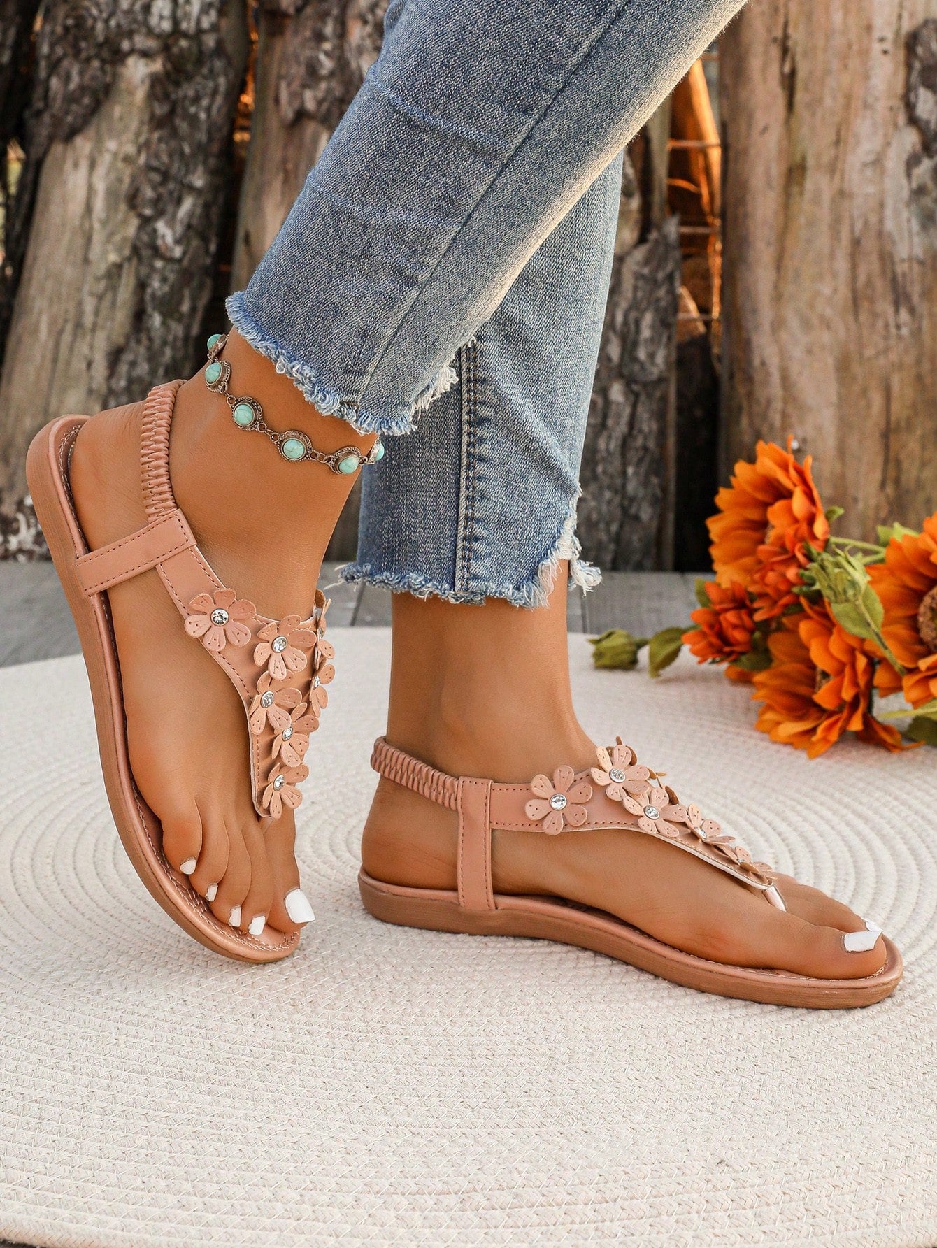 Women's white flat beach thong sandals with toe-post design, featuring flower applique and rhinestone embellishment on the upper, casual summer slide style.