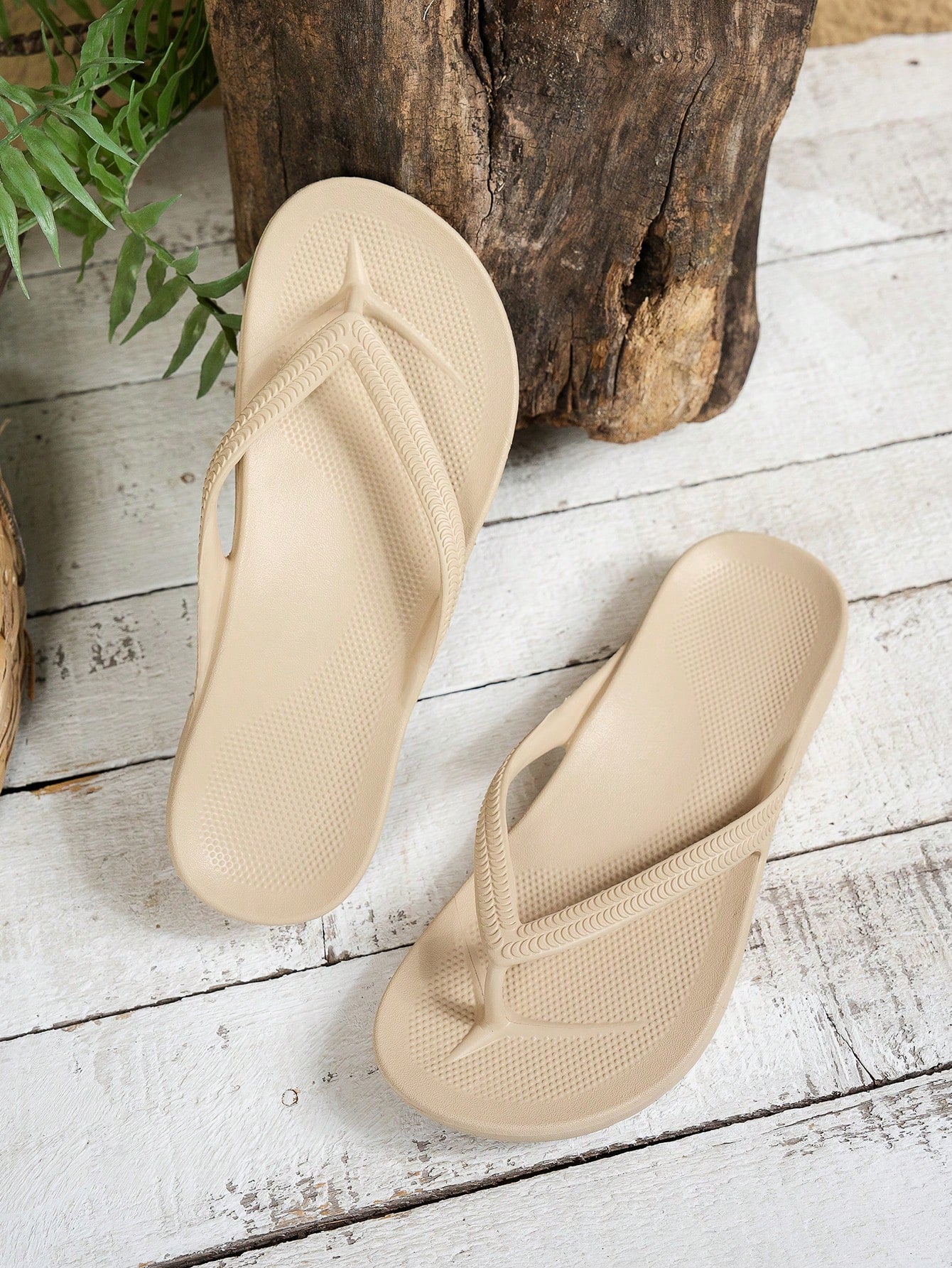 Women's solid color flip flops with open-toe design, flat sole, and cut-out details, suitable for casual indoor or outdoor wear at the beach or pool.