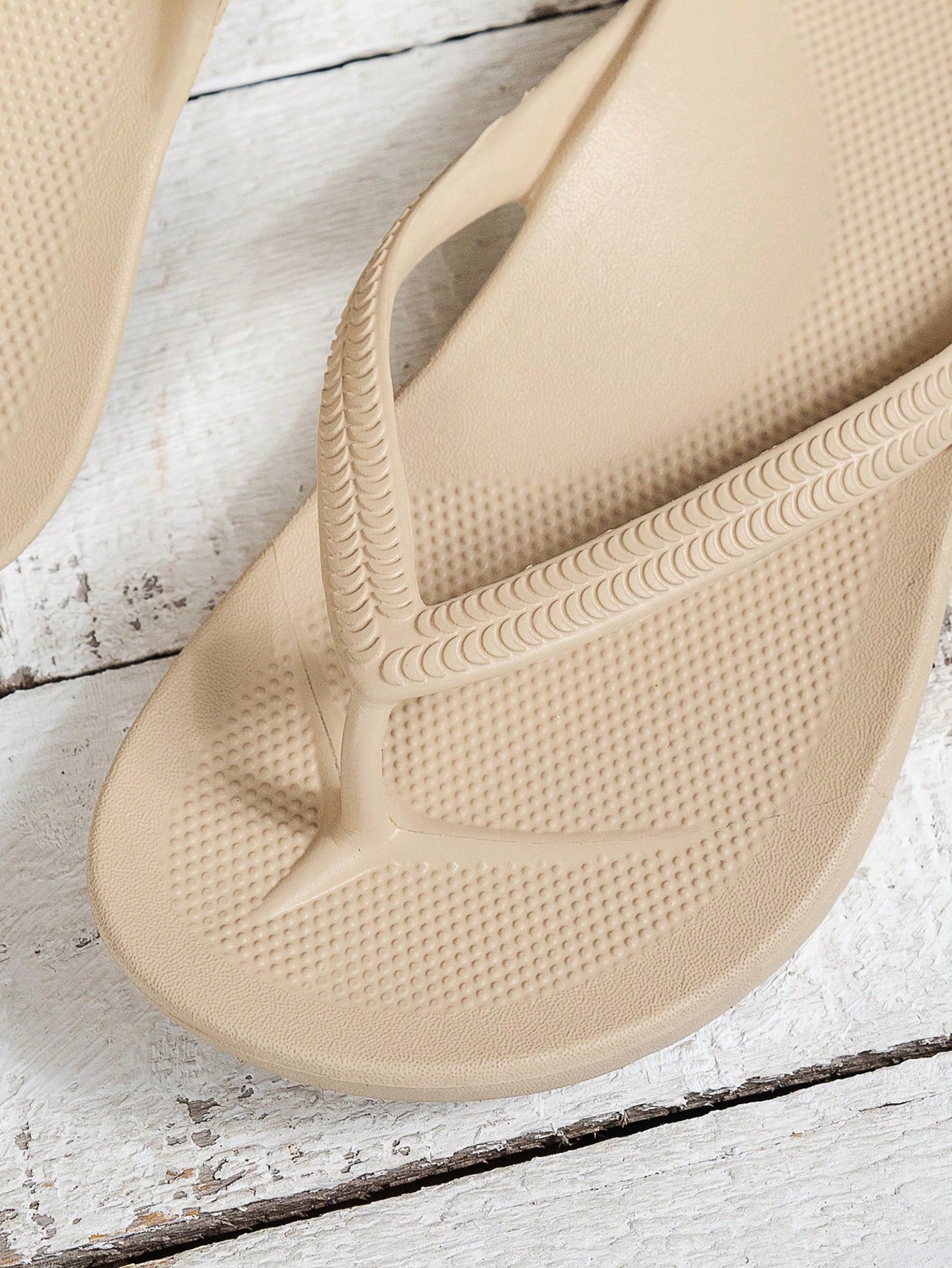 Women's solid color flip flops with open-toe design, flat sole, and cut-out details, suitable for casual indoor or outdoor wear at the beach or pool.