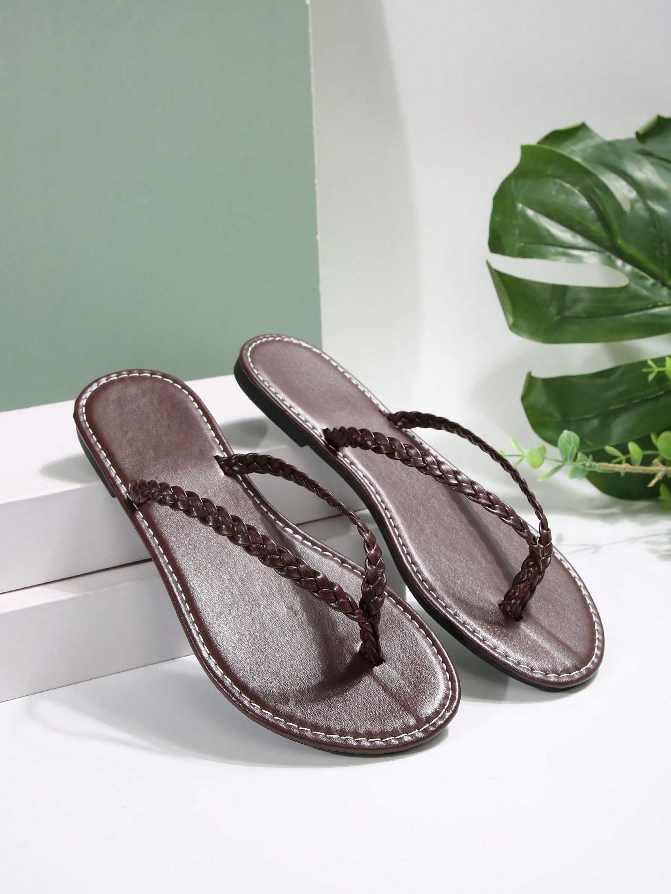 Women's chocolate brown flat flip flop sandals featuring a toe-post thong style and braided detail, suitable for casual indoor and outdoor wear.